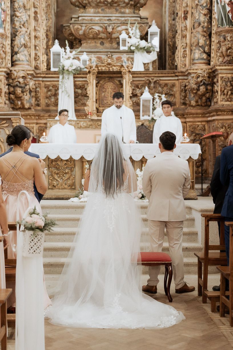 Cerimônia de casamento realizada em uma igreja barroca ornamentada, com decorações douradas elaboradas e detalhes arquitetônicos. All Got