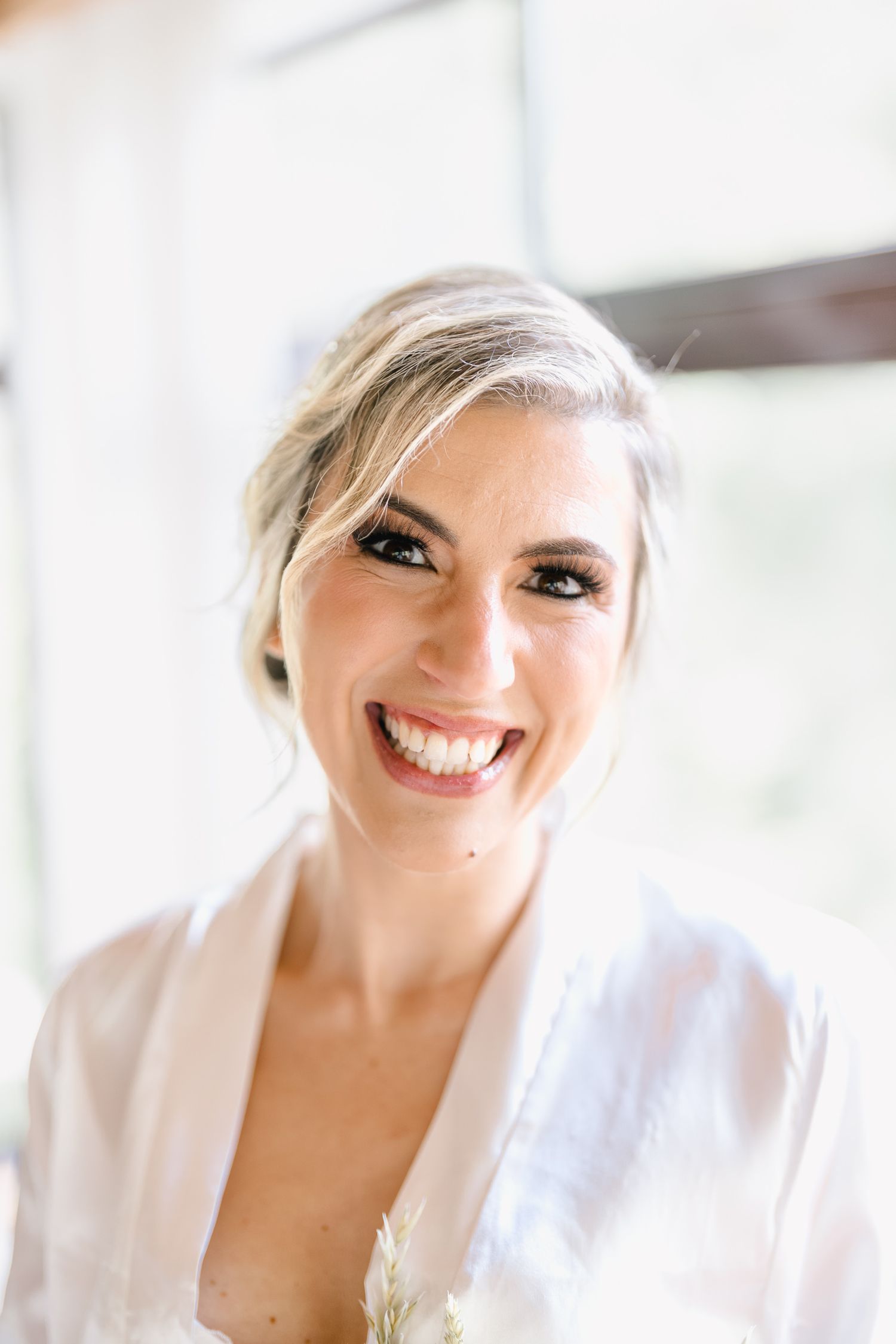 Bright and airy bridal portraits showing joyful expressions and natural window lighting.