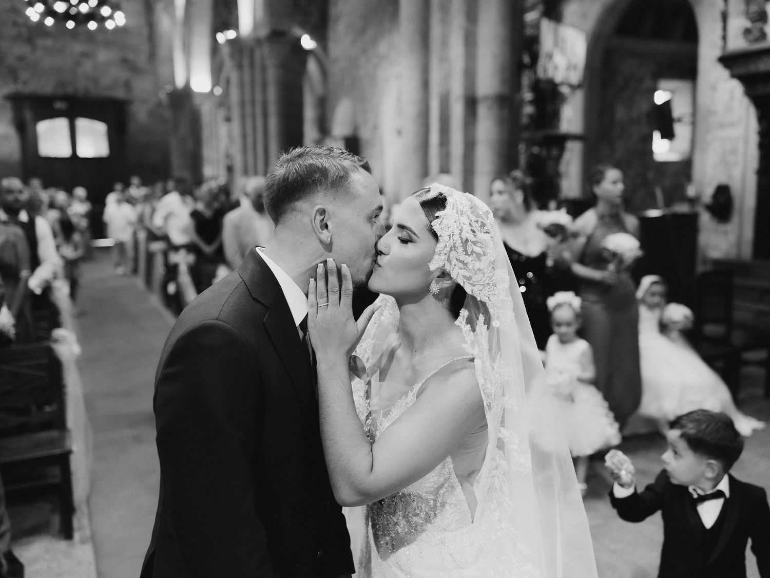 A black and white photo collage showing various wedding moments with dancing, embraces and celebrations at a reception.