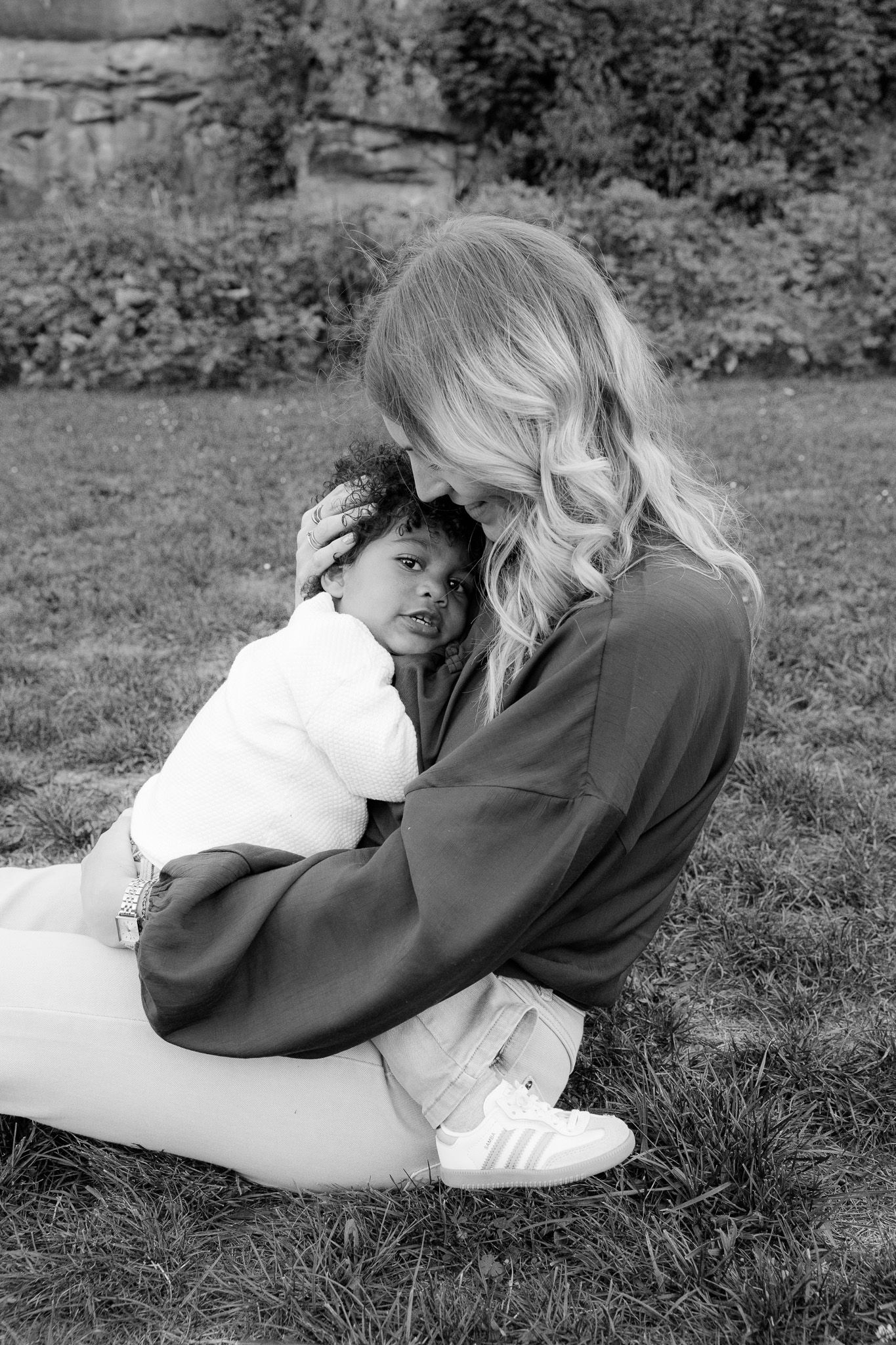 Black and white photo of a mother holding her toddler in the grass, Familienfotografie Rems-Murr