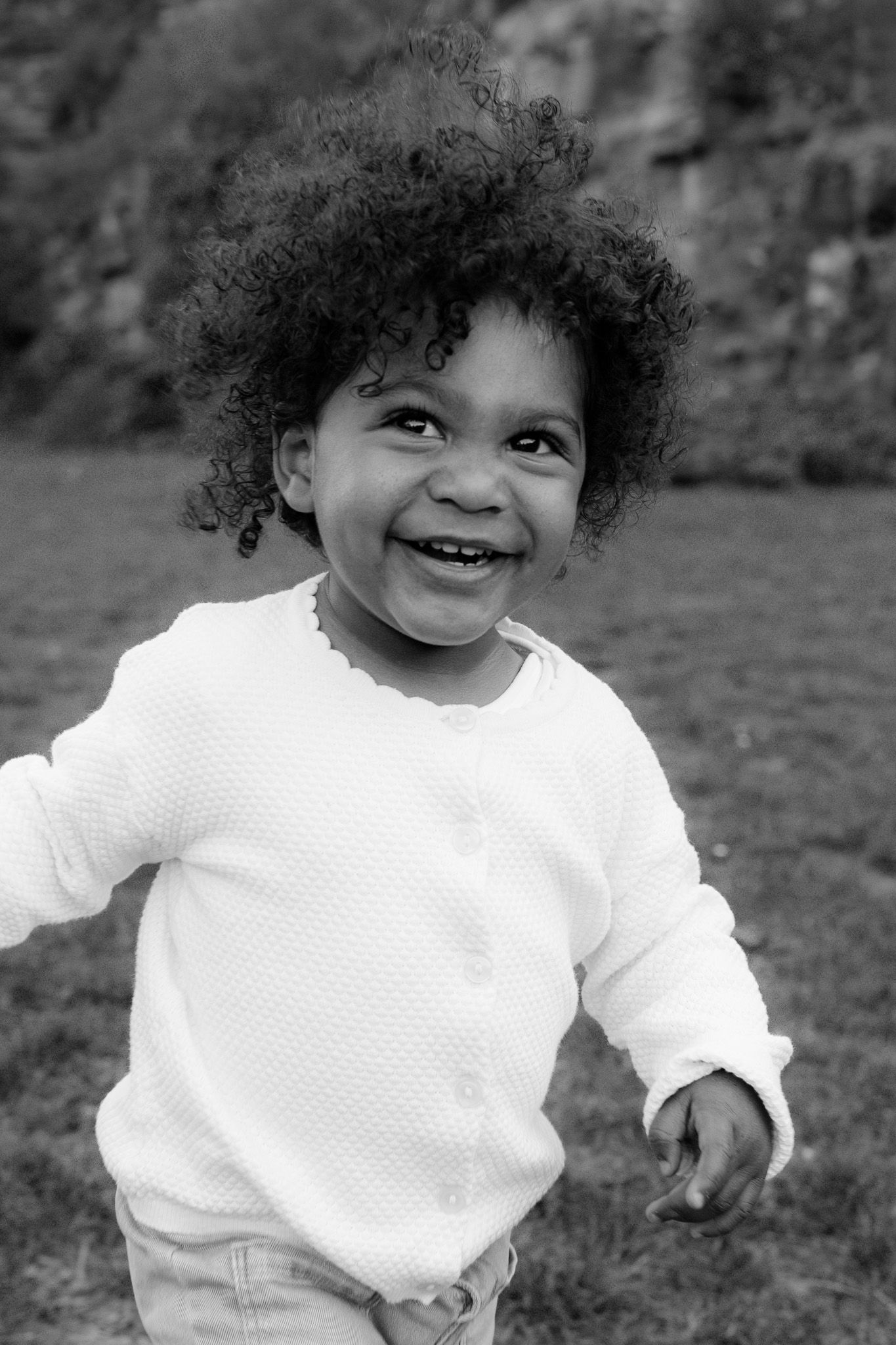 Black and white portrait of a laughing toddler with curly hair, Kinderfotografie