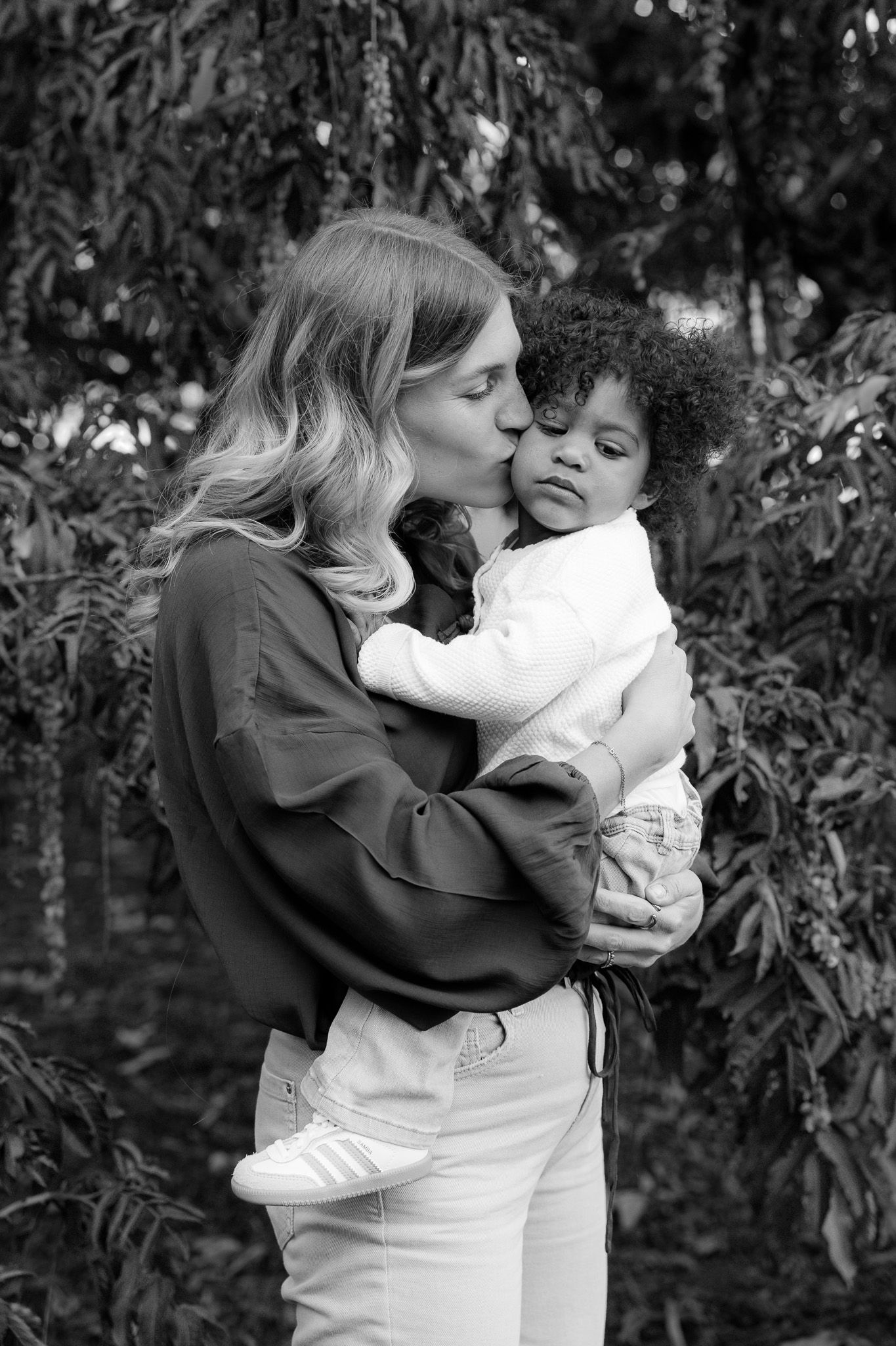 Black and white photo of a mother kissing her toddler’s cheek, Familienshooting