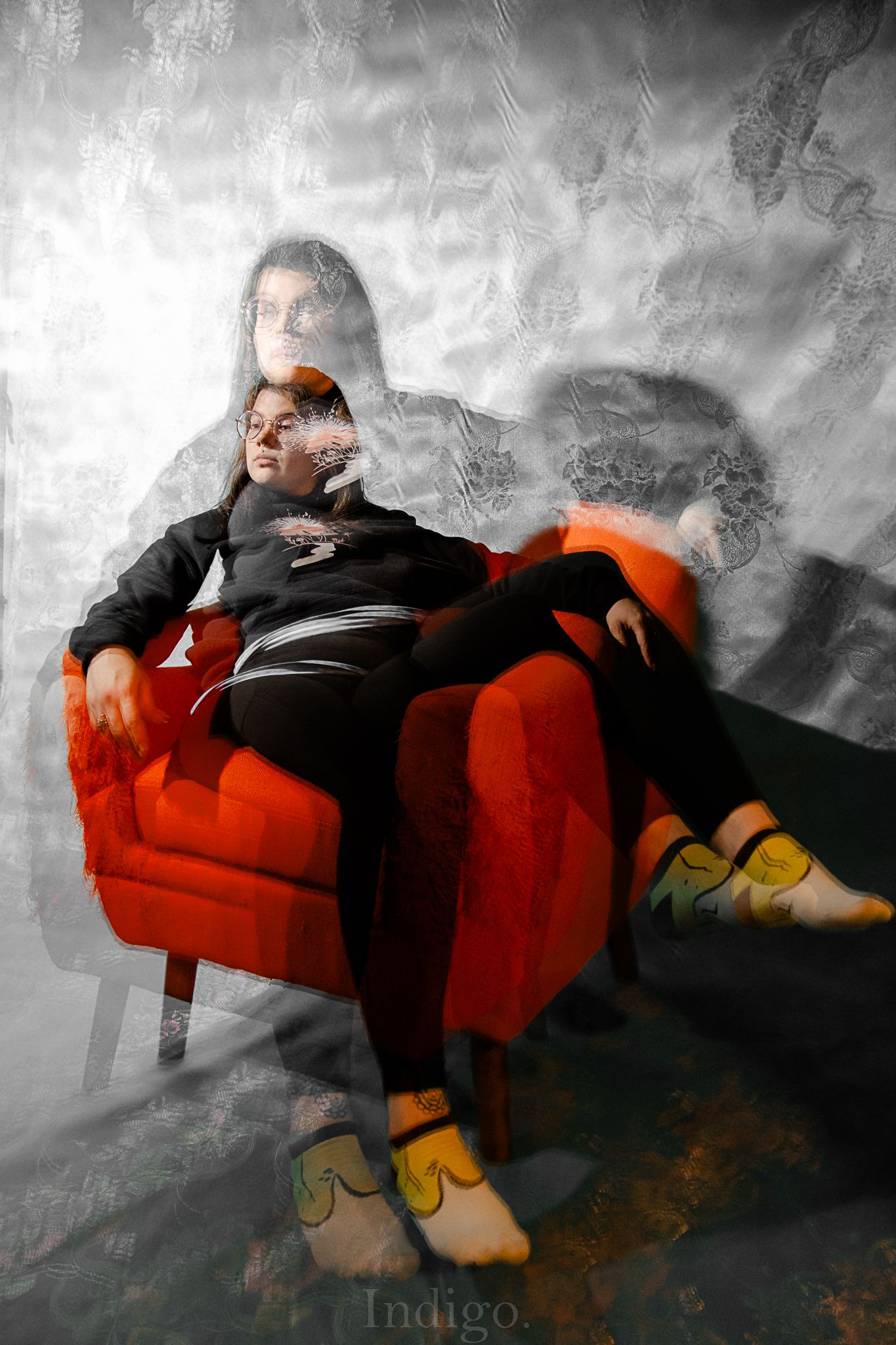 Artistic photo series of a person lounging on a red couch against a moody gray background.