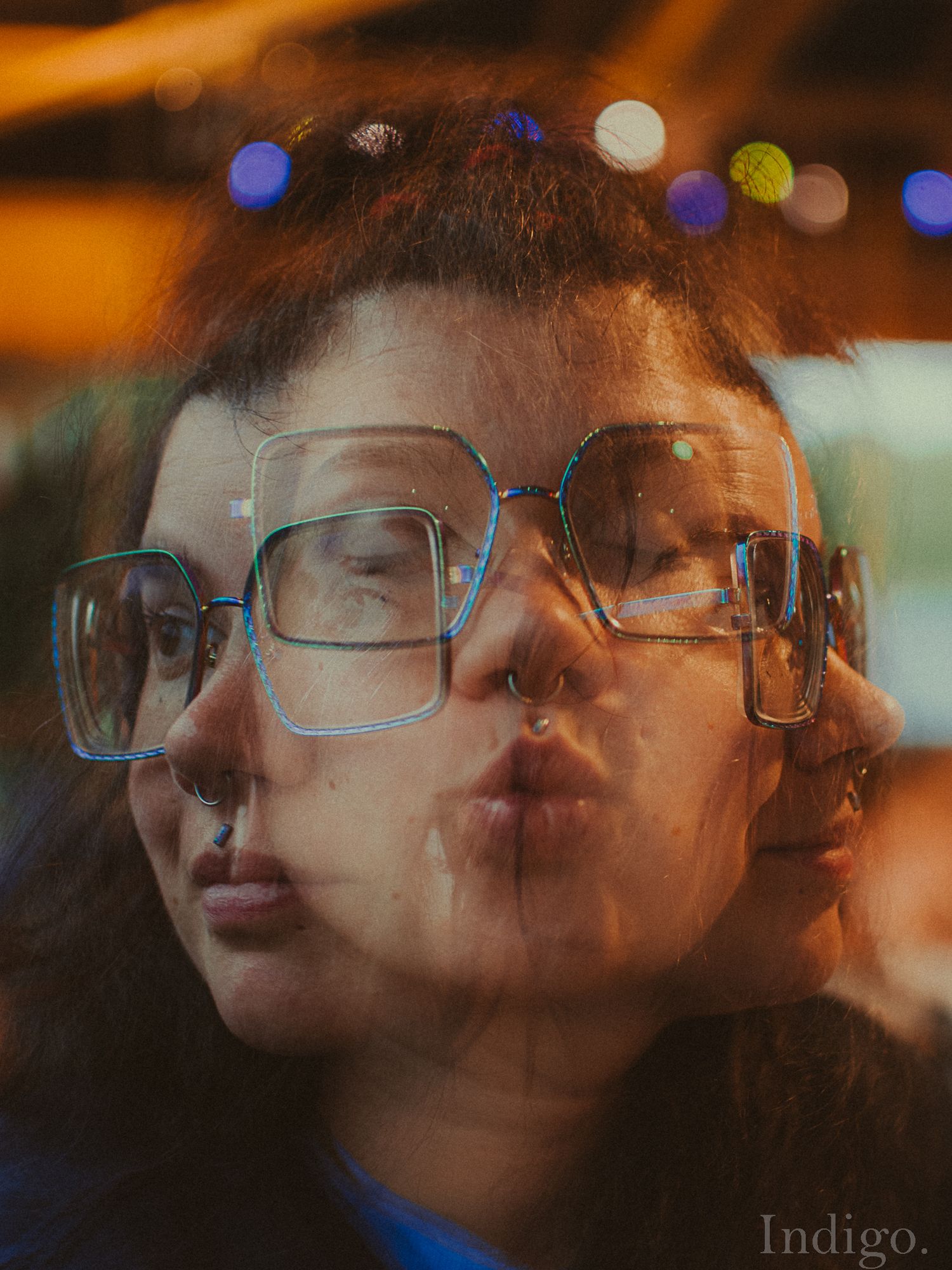 Multiple exposure portrait with warm bokeh lights and reflective elements.