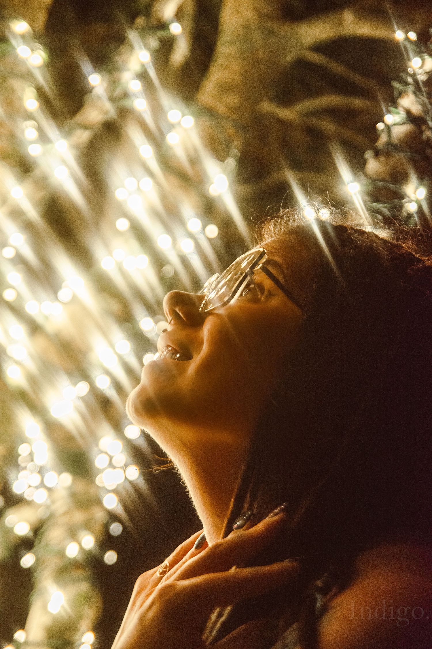 Upward view of sparkling lights creating a magical bokeh effect in warm tones.