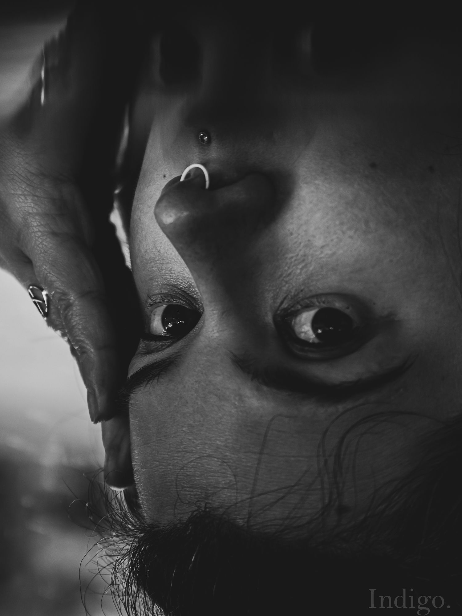 Close-up black and white portrait with dramatic shadows and lighting.