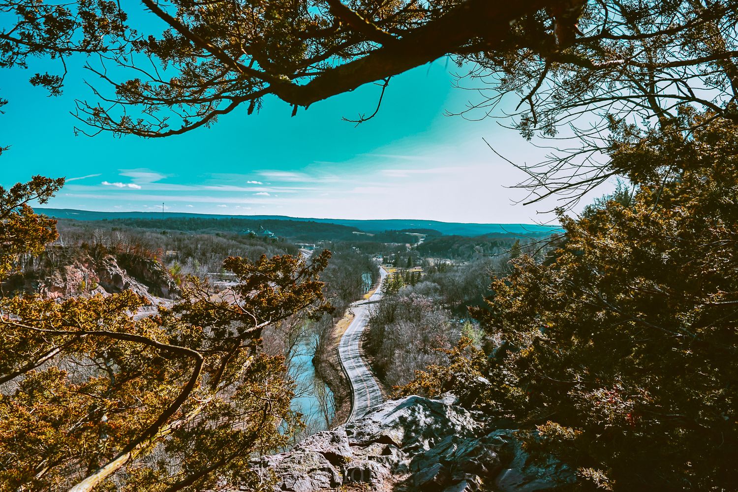 Panoramic aerial view of a scenic mountain landscape with autumn foliage and winding roads through valleys.