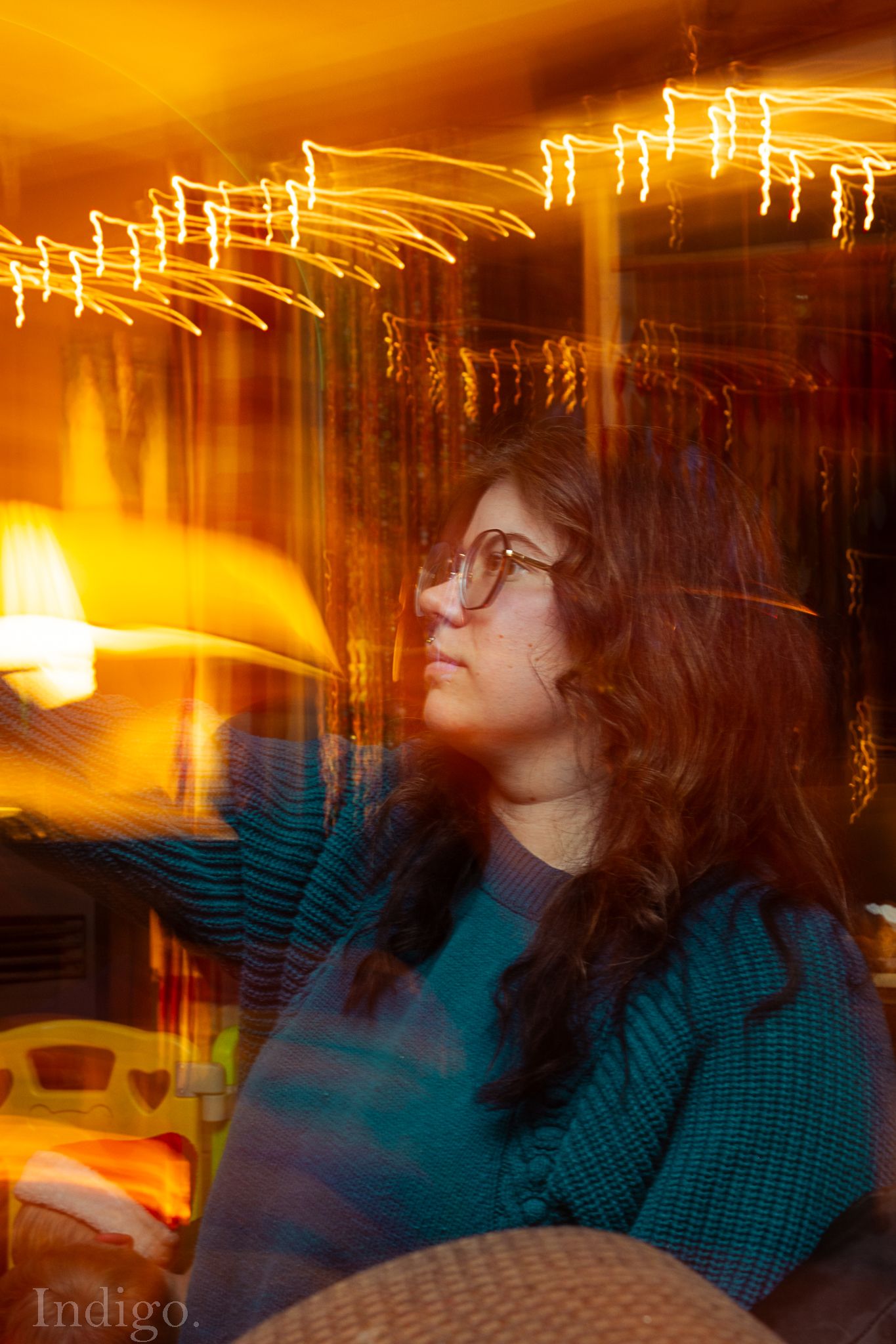 Artistic long exposure photo with swirling orange light trails against a dark background.