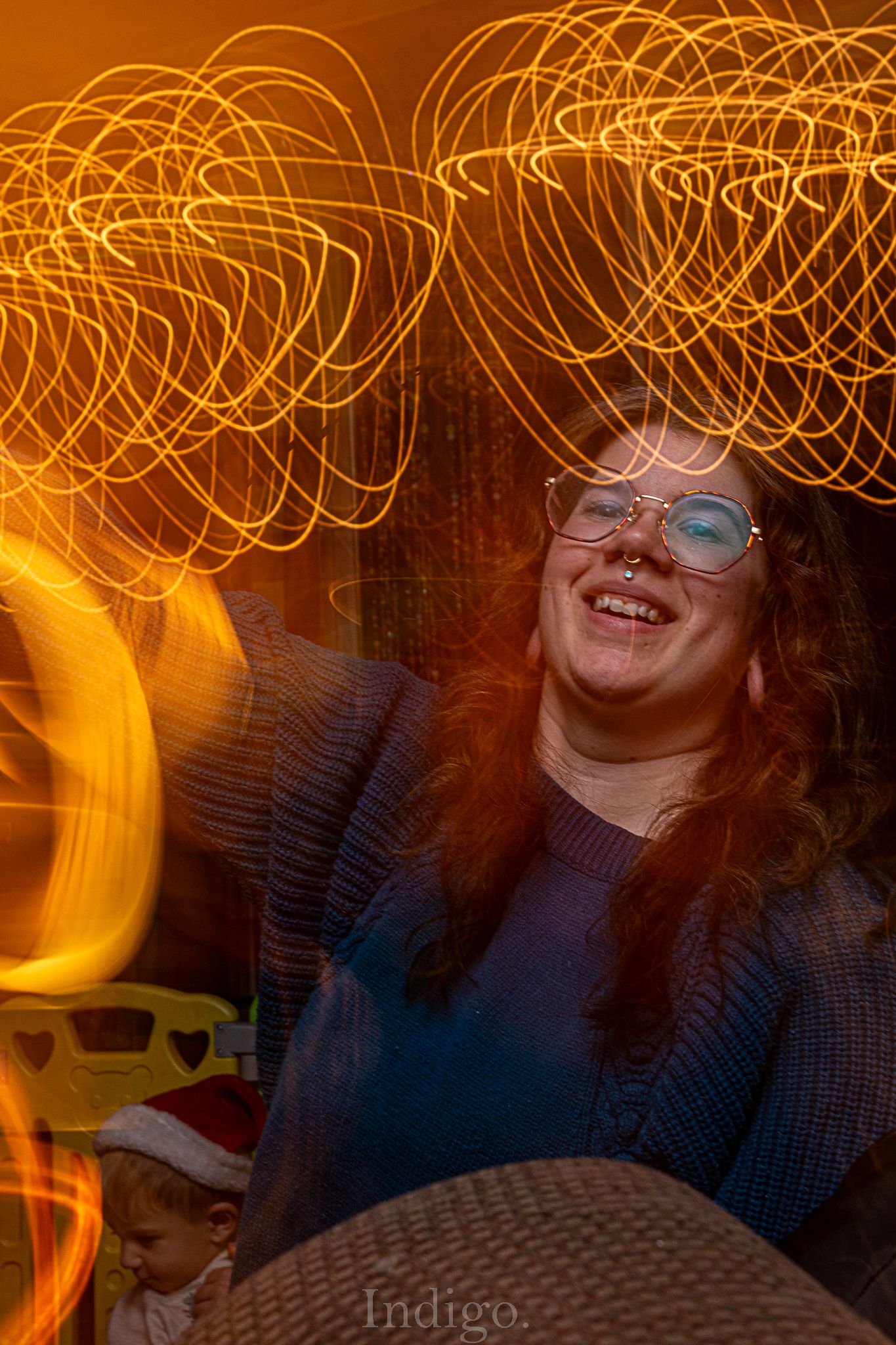 Creative light painting photograph showing golden spiral patterns in a dimly lit setting.