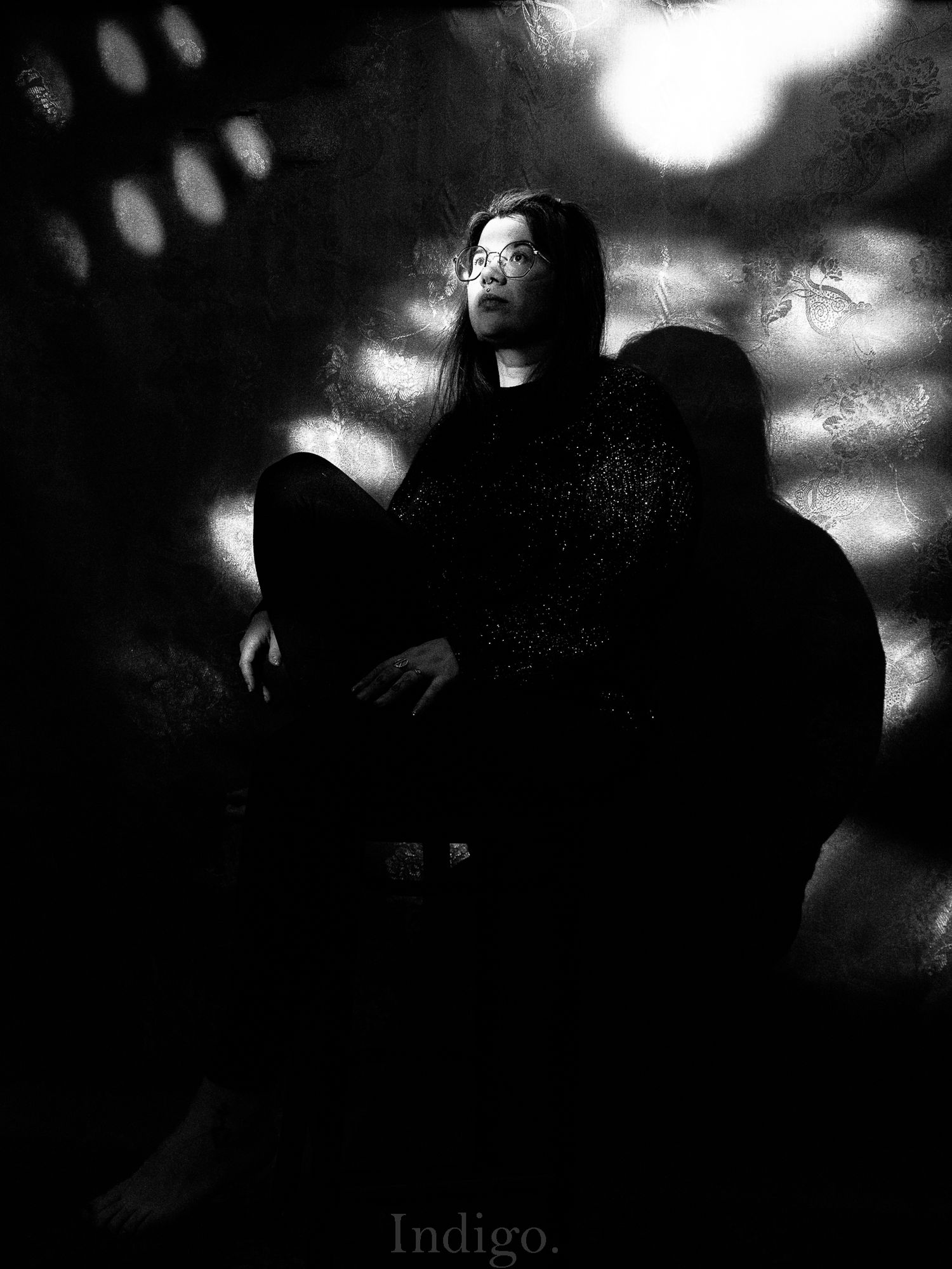 Moody black and white photograph with blurred lights and silhouettes.