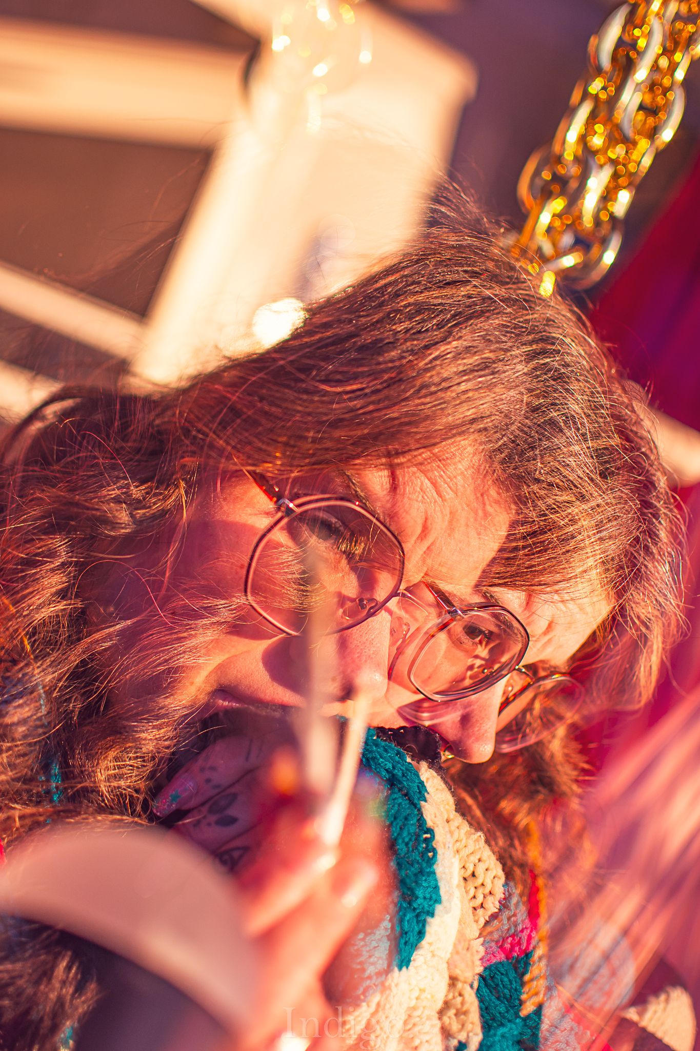 Artistic sequence showing movement with teal and red tones under string lights.