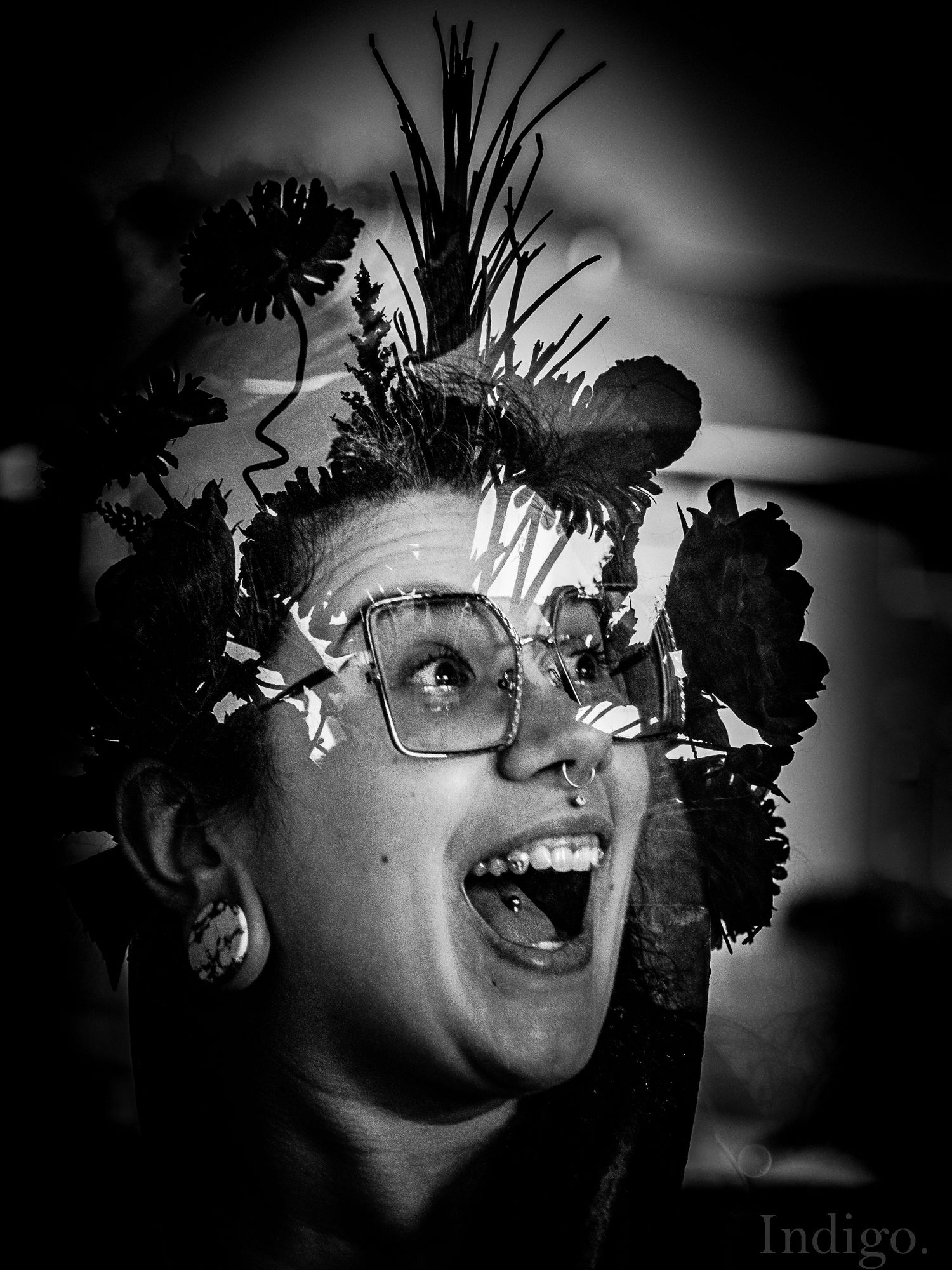 Black and white portrait wearing a floral crown with expressive joy.