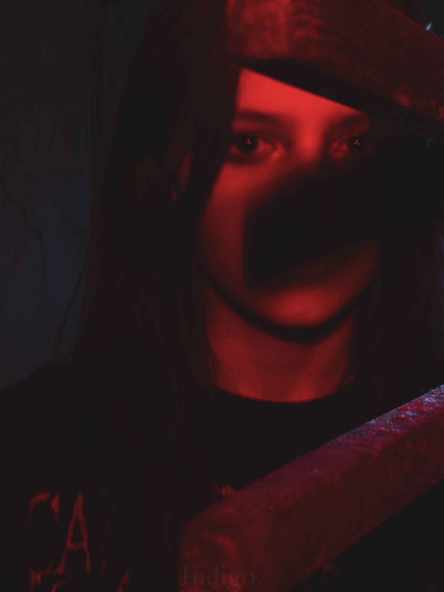 Dramatic portrait in dark red lighting creating moody atmosphere.