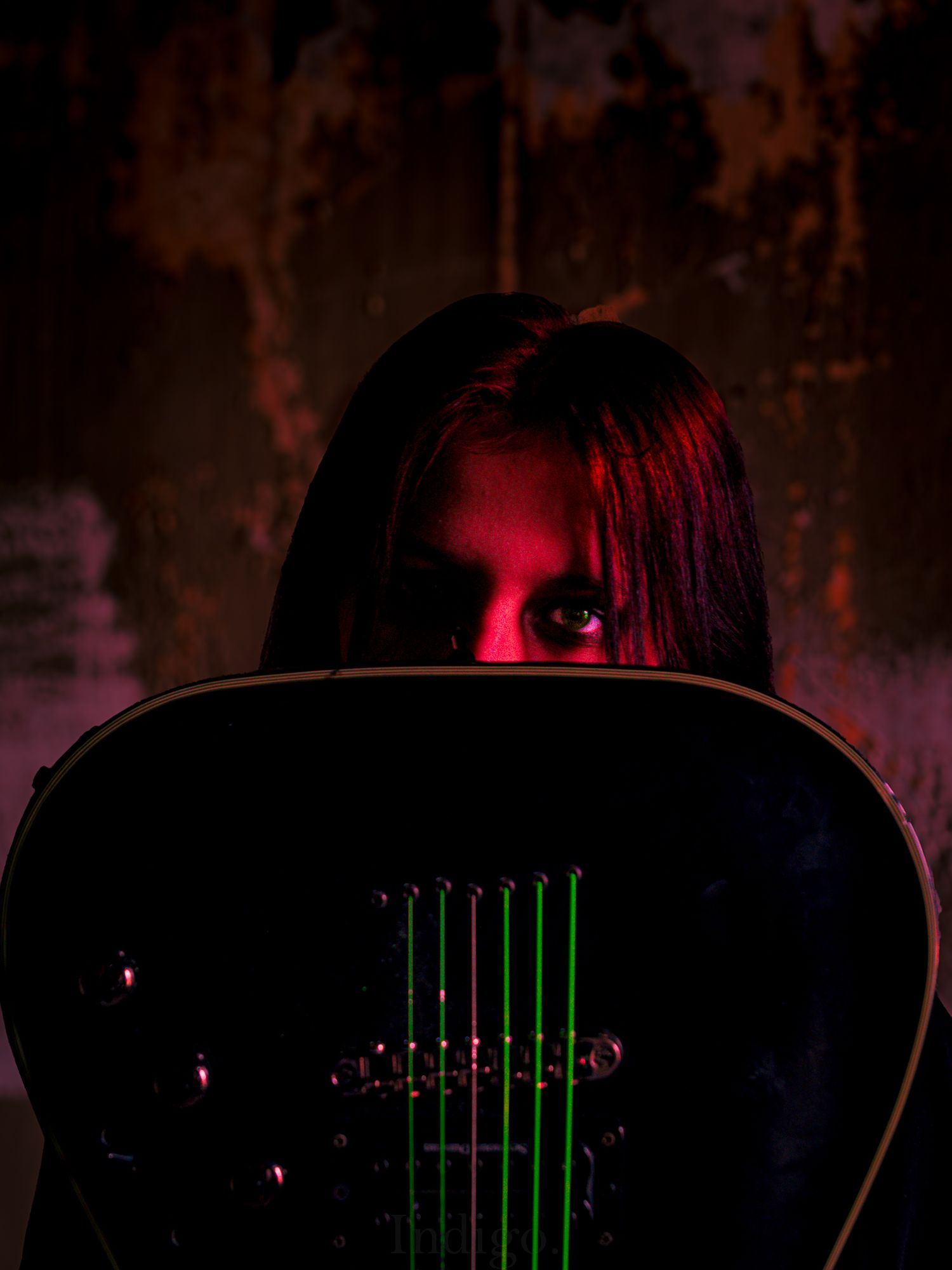 Guitar strings and neck silhouetted against dark background with red accent lighting.