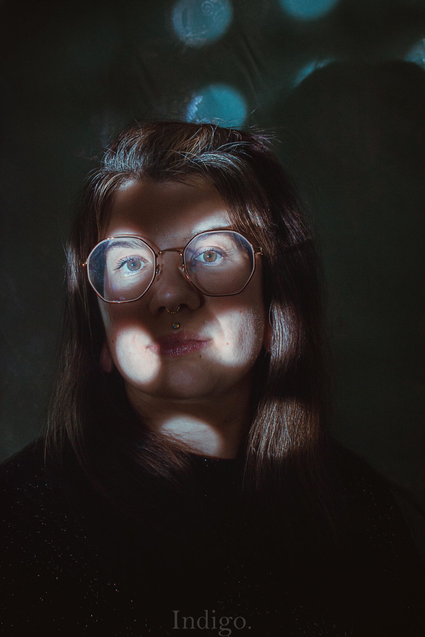 Moody artistic portrait series in dark lighting with blue tones and glasses showing dramatic shadows and lighting effects.