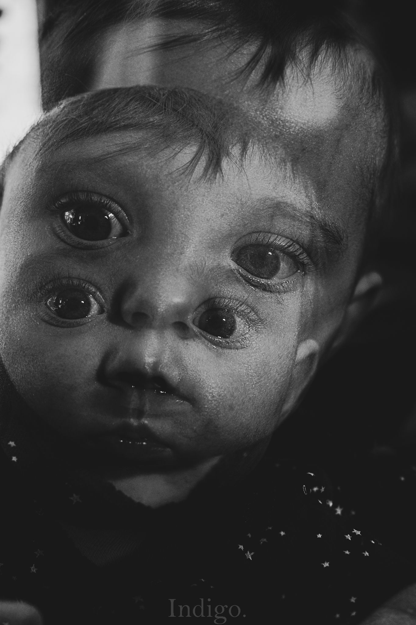 Dramatic black and white portrait with intense shadows and highlights.