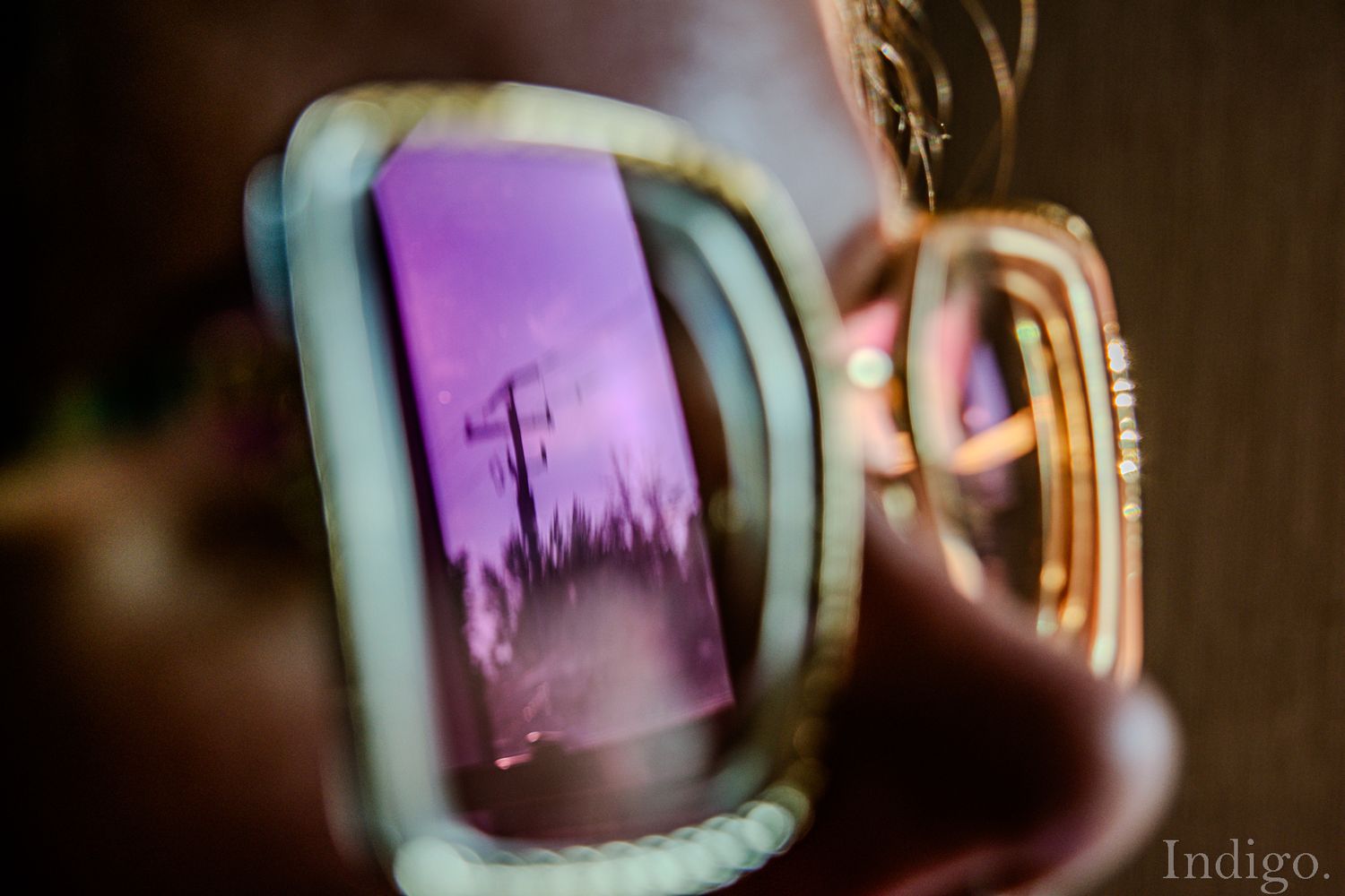 Purple church silhouette reflected in glasses lens at sunset.