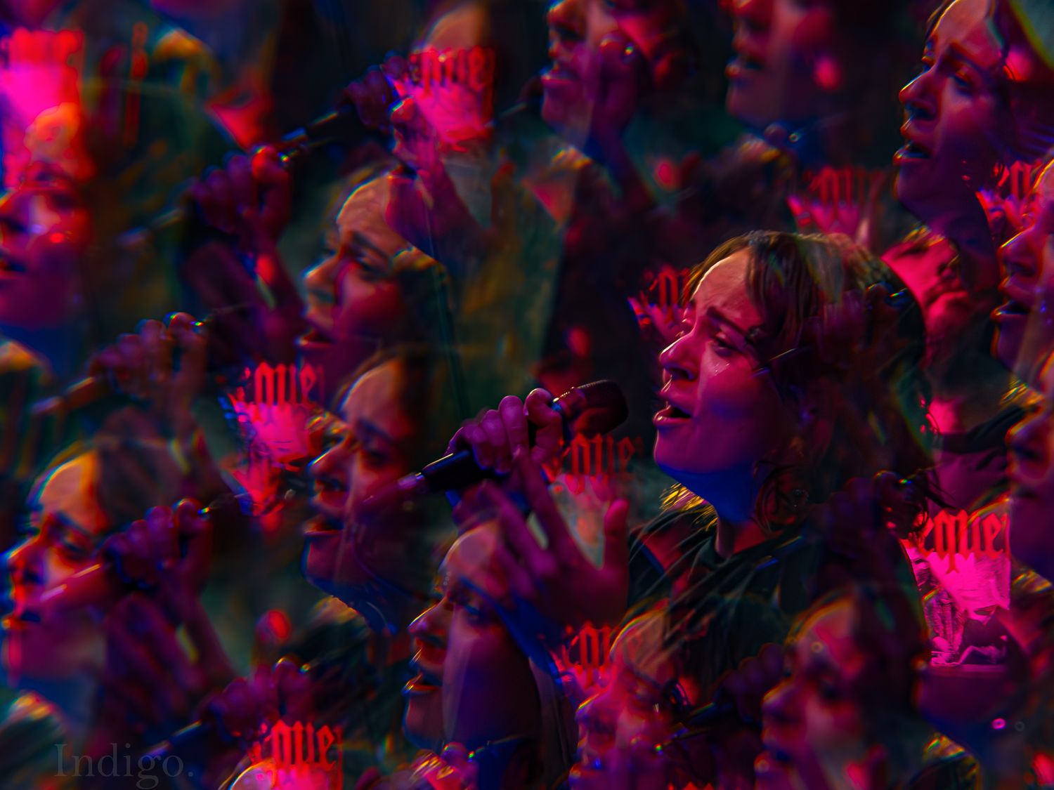 Concert crowd illuminated by vibrant pink and purple lighting effects.