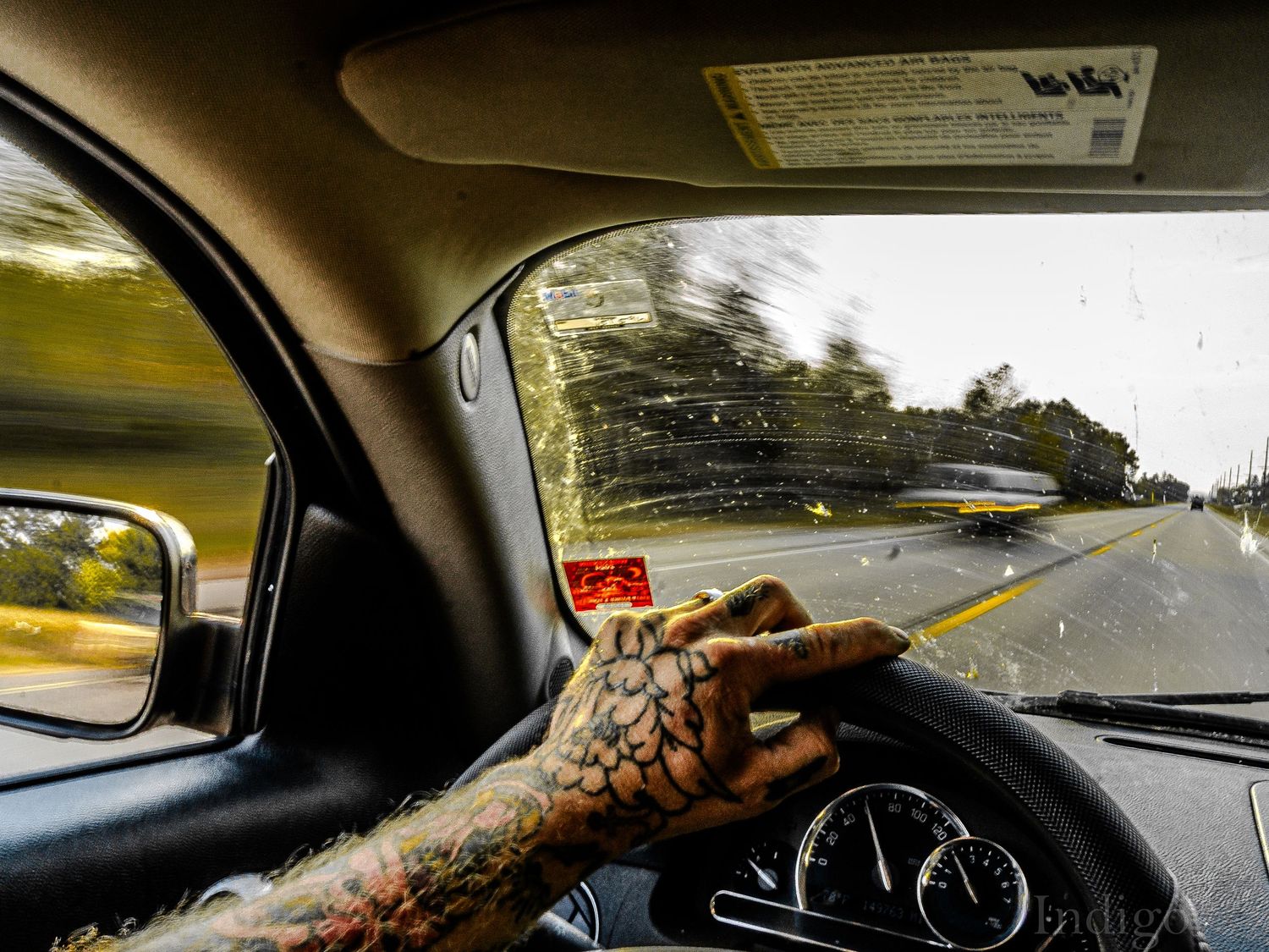View from inside a car showing the dashboard and road ahead through the windshield.