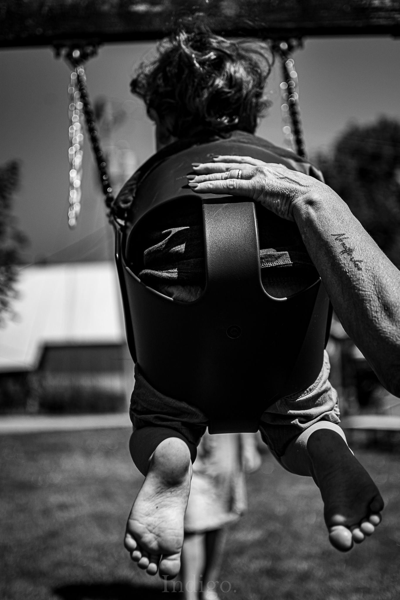 Black and white photo series showing bare feet swinging in sequence.