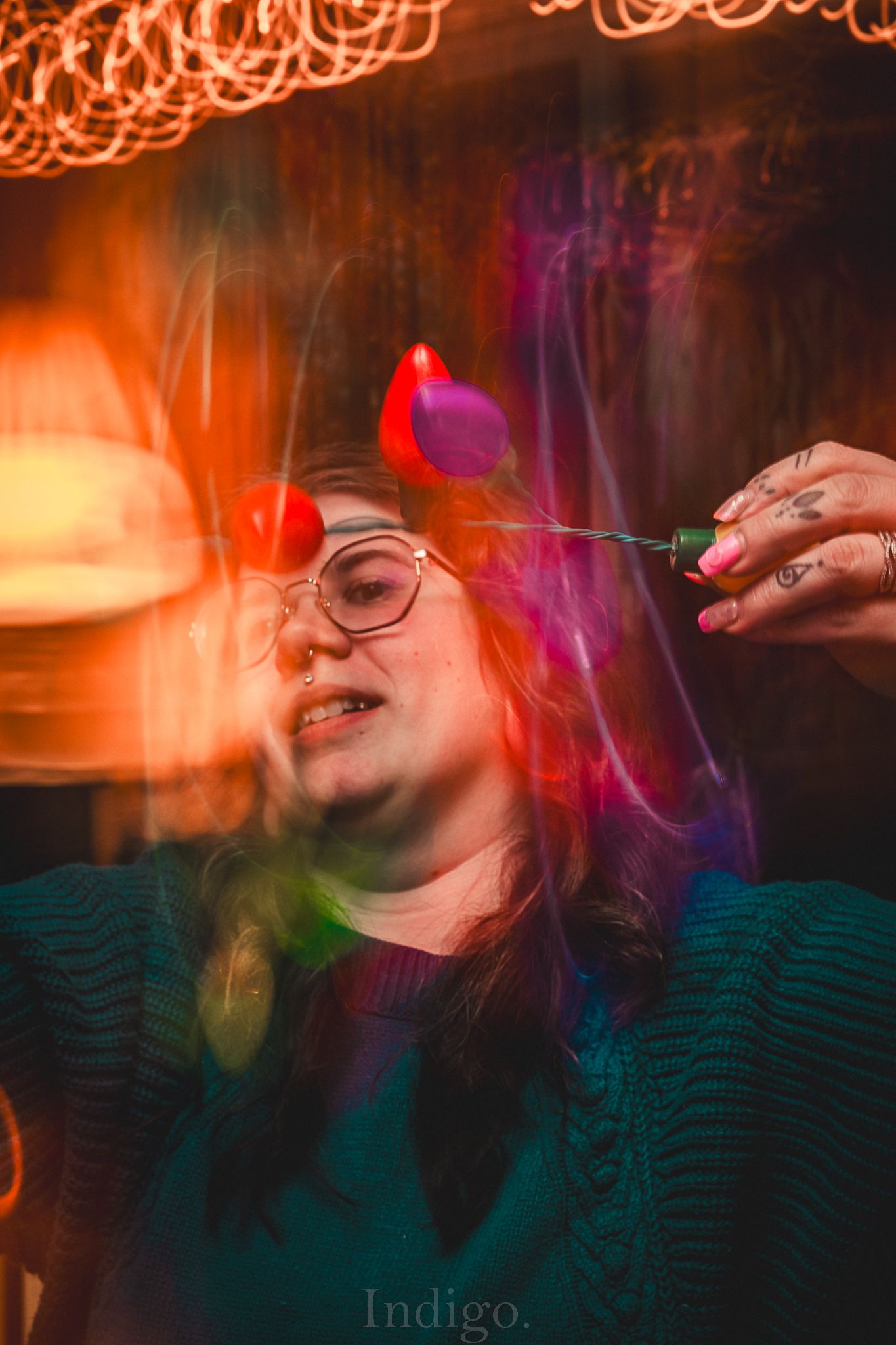 Artistic portrait with orange light trails and vibrant colors against a dark background.