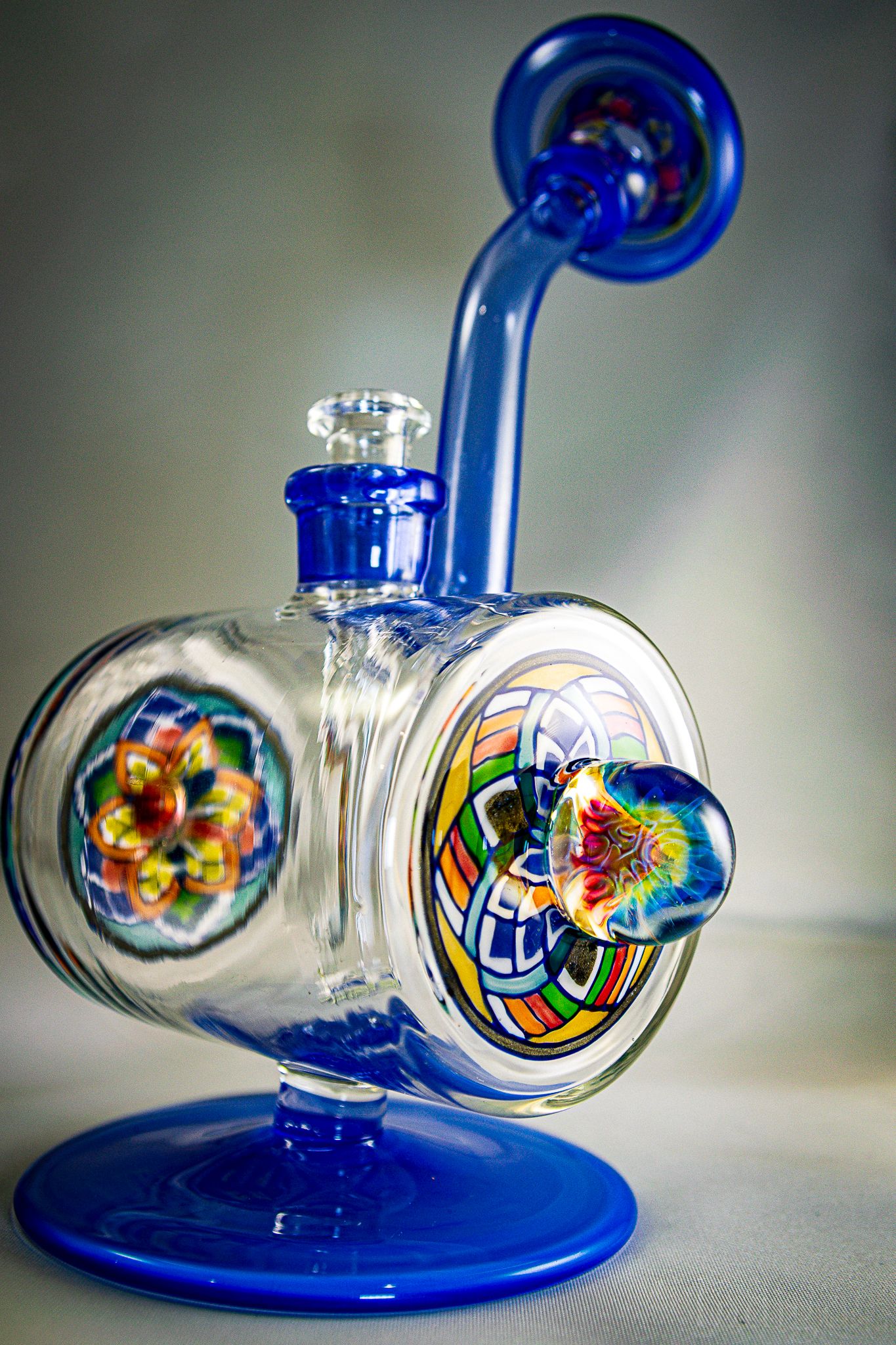 Artistic shots of a blue glass water pipe with colorful decorative details.