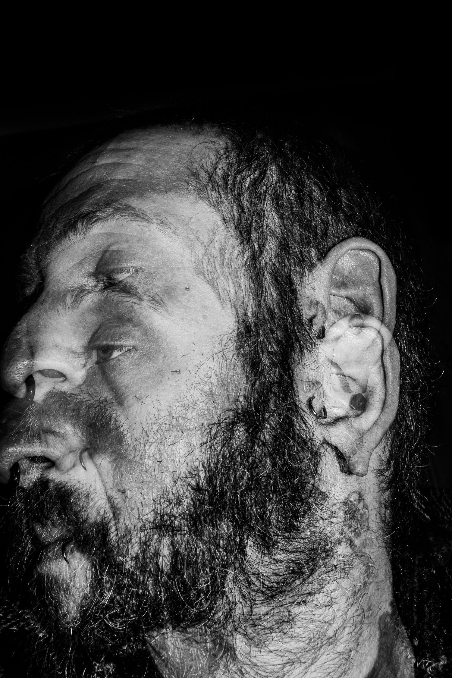 Black and white portrait series showing different angles of a bearded face in dramatic lighting.
