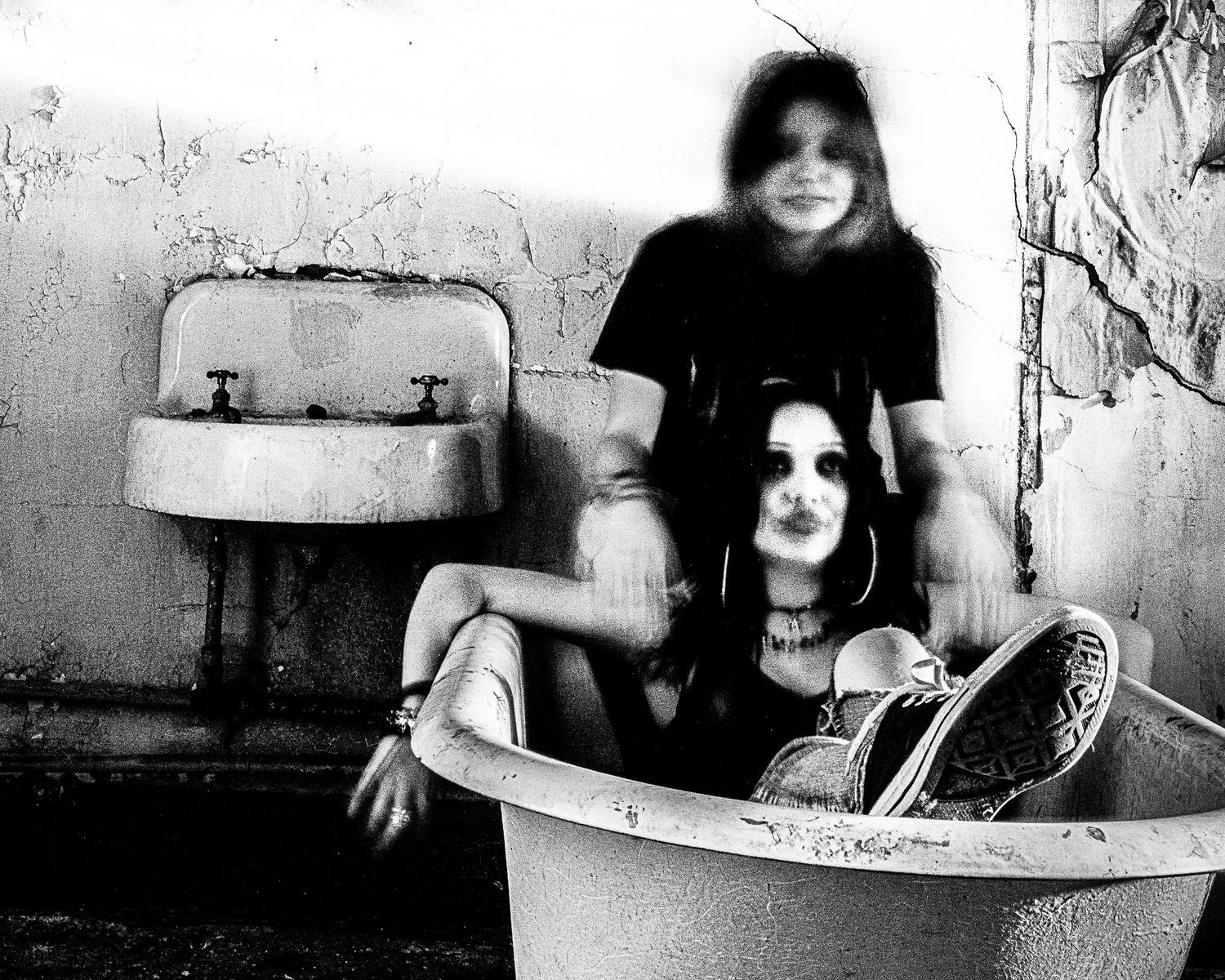 Artistic black and white photo of a bathtub in a grungy setting.