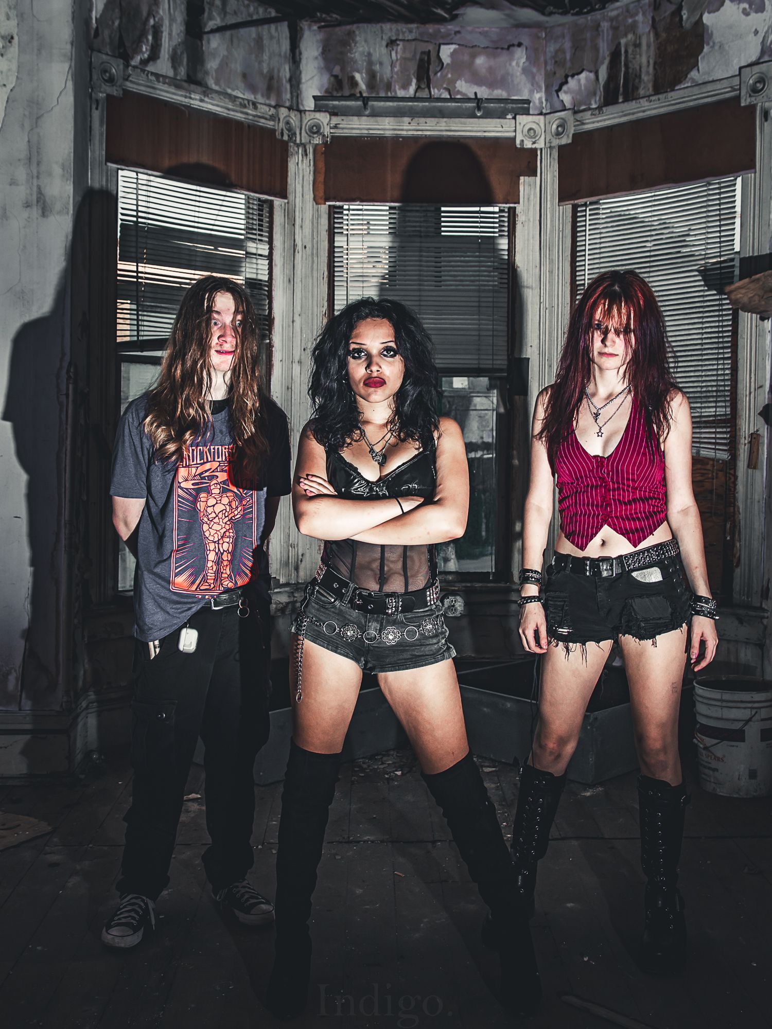 Group photo in an industrial setting with gothic fashion aesthetic.