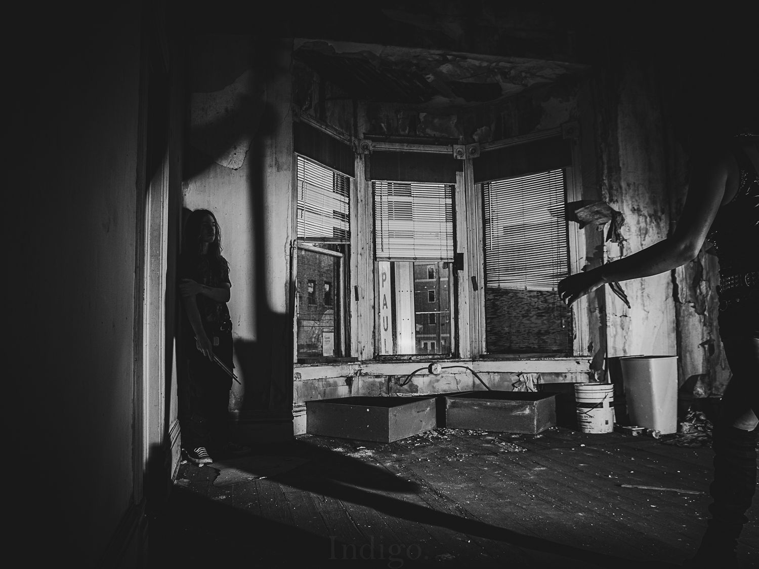 Panoramic view of a dimly lit abandoned building interior.