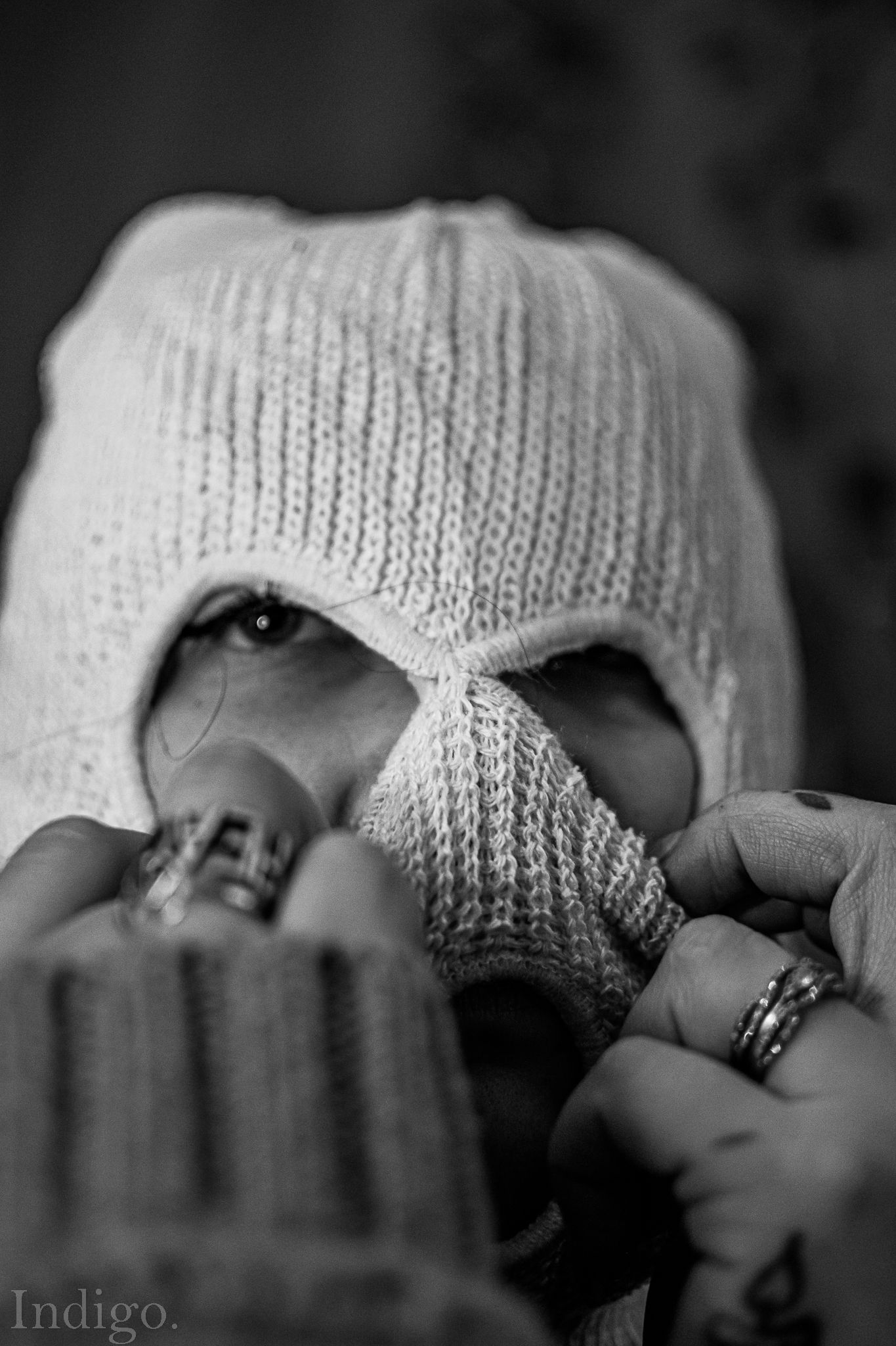 Dramatic black and white close-up of knitted fabric with jewelry details.