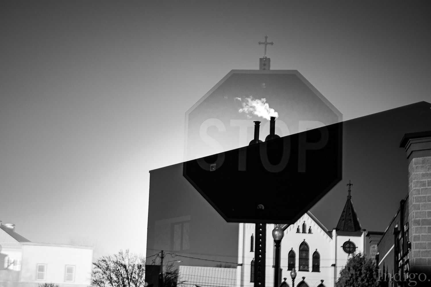 Black and white cityscape silhouette featuring church spires and buildings at dusk.