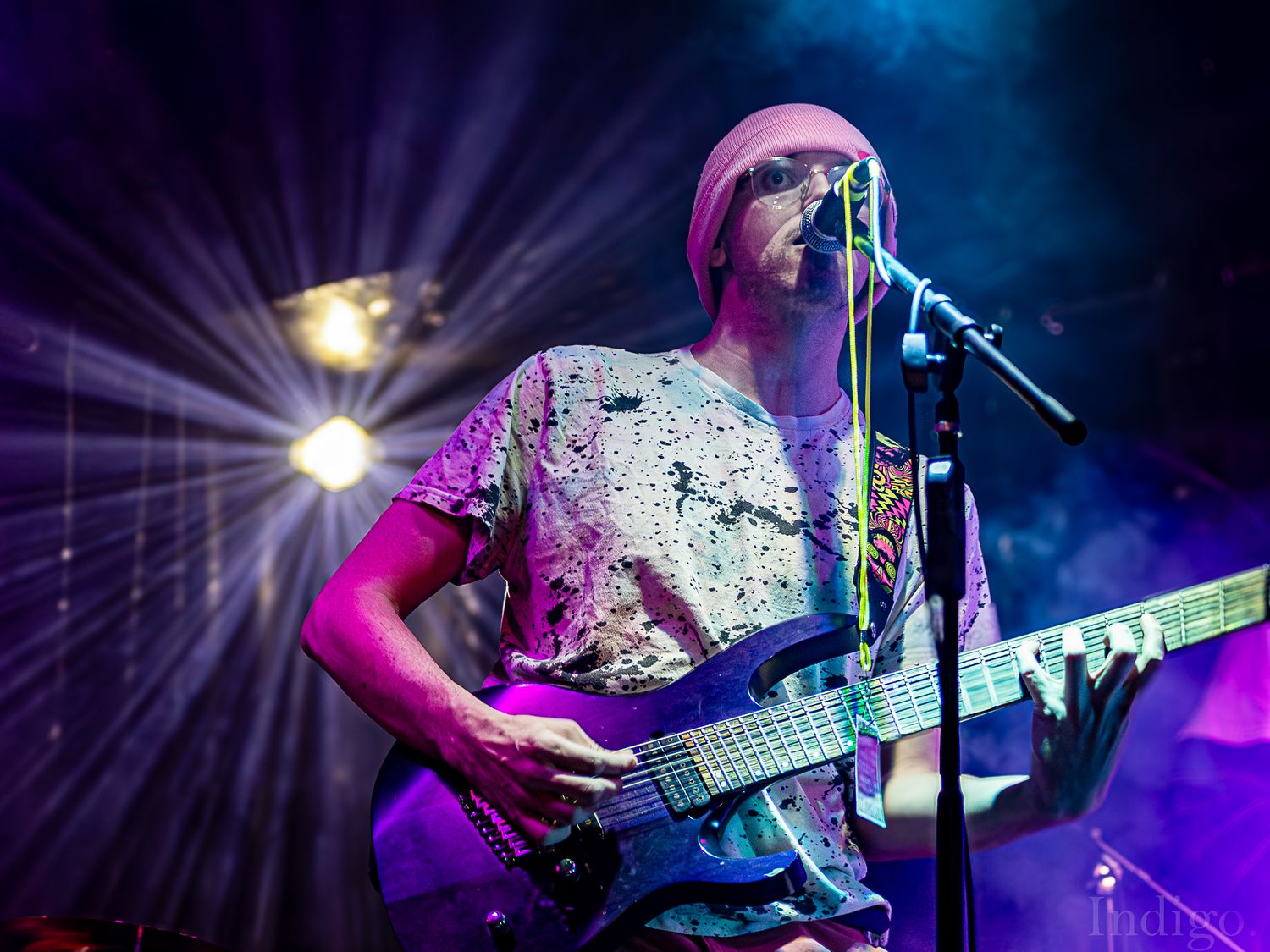 Concert stage illuminated with purple and blue lights during a live musical performance.