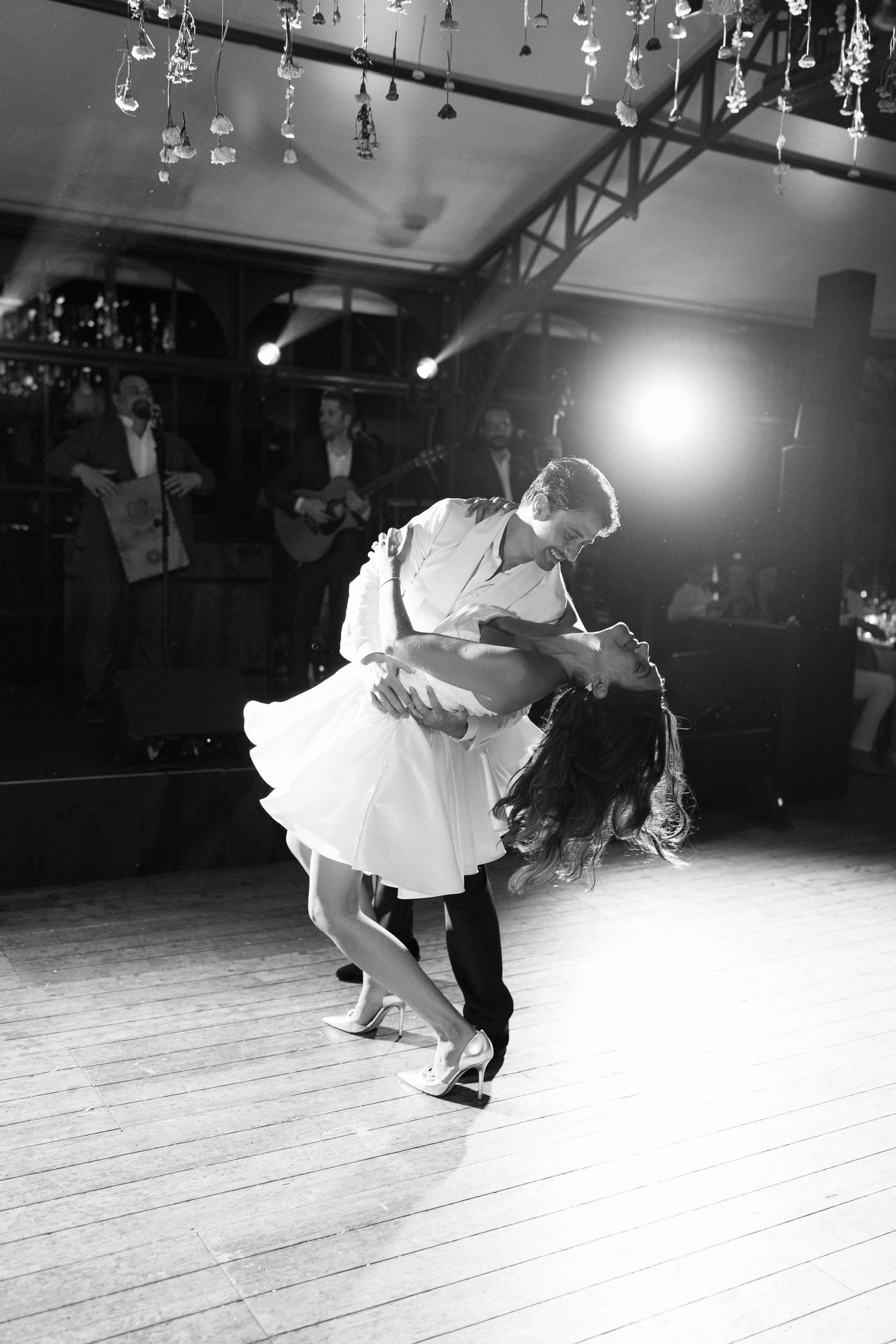 Black and white dance sequence showing dramatic swing dance movements on wooden floor.