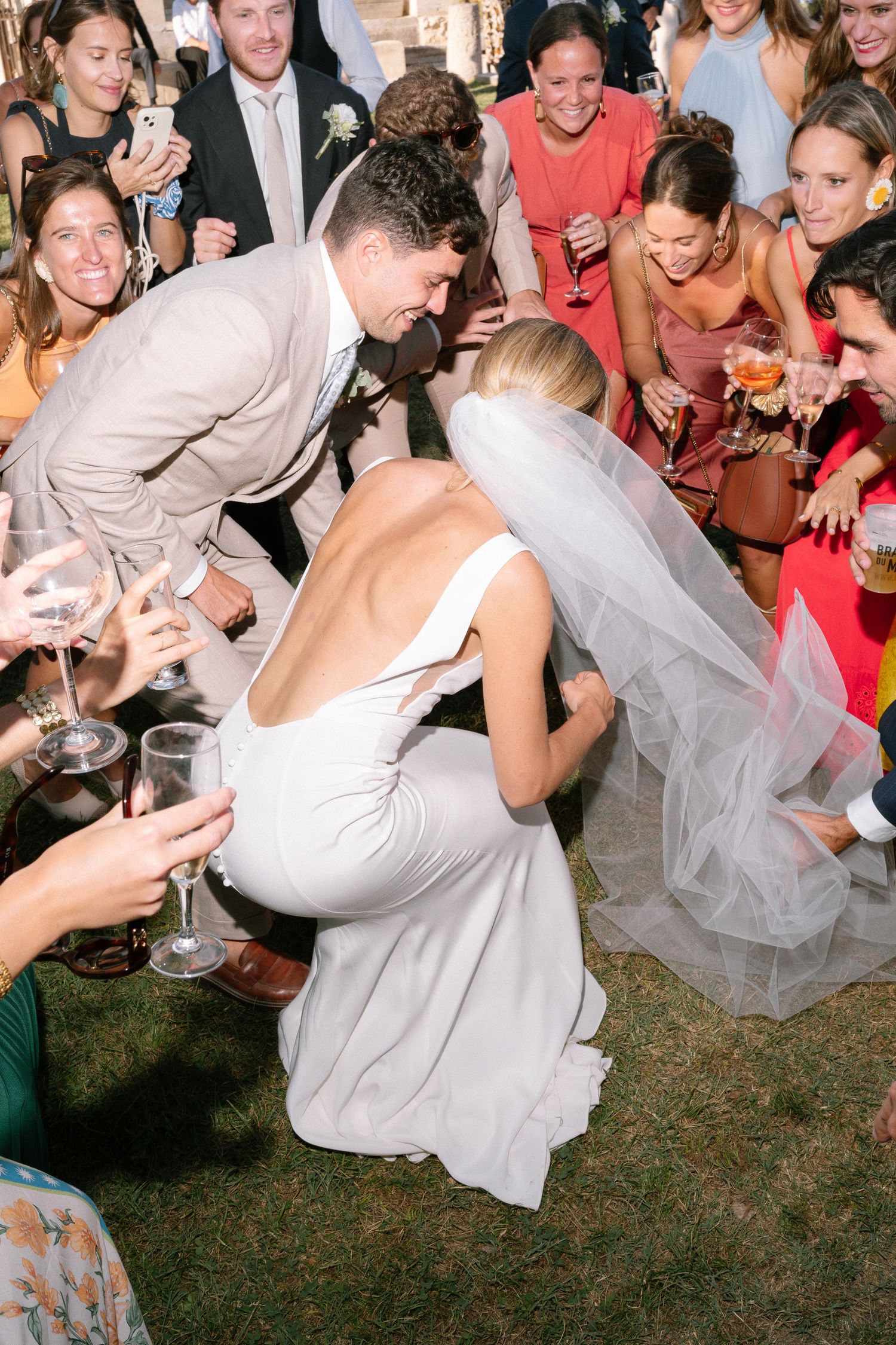 Wedding guests dance and celebrate on an outdoor dance floor.