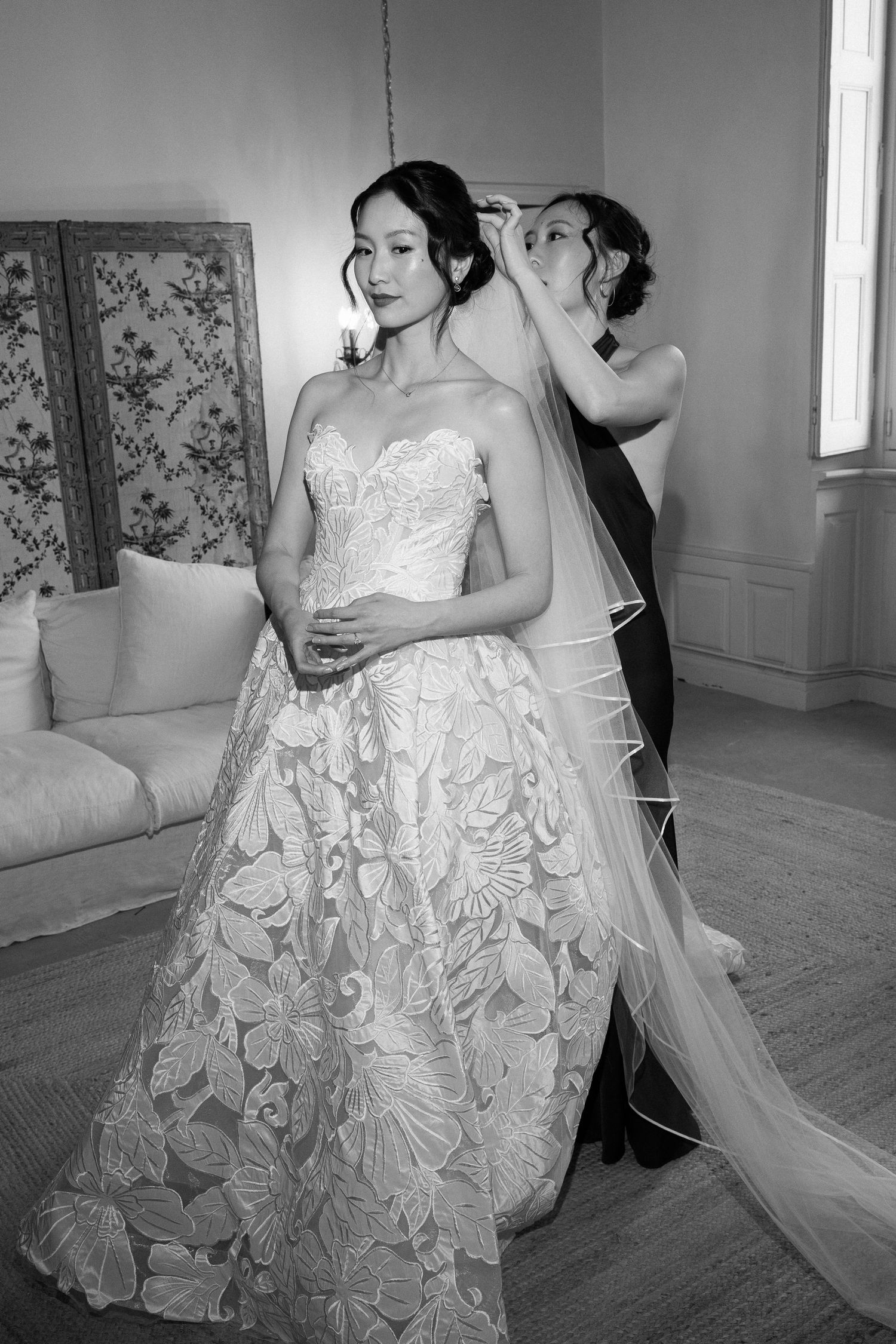 Black and white photos showing intricate details of a lace wedding gown and veil.