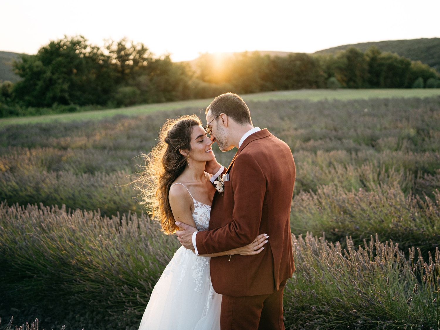Romantic sunset portraits in a golden field with flowing white wedding dress.