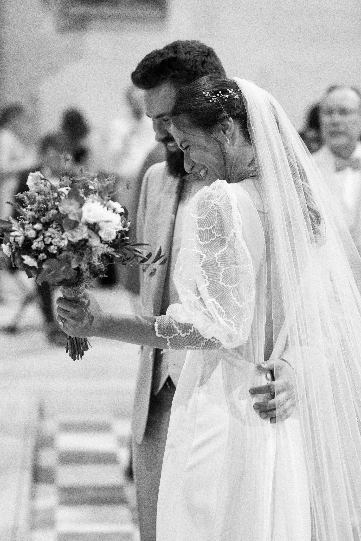 Elegant wedding ceremony details showing white lace dress and floral bouquet.