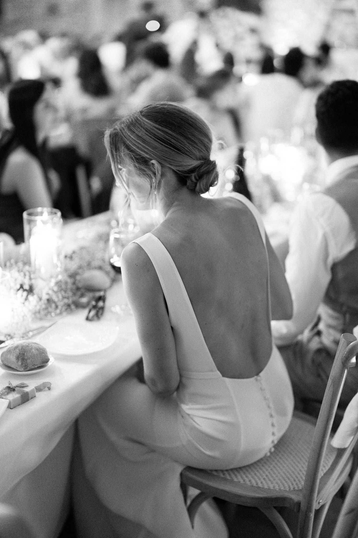 Elegant wedding reception tables set with white linens and glassware in a formal dining setting.