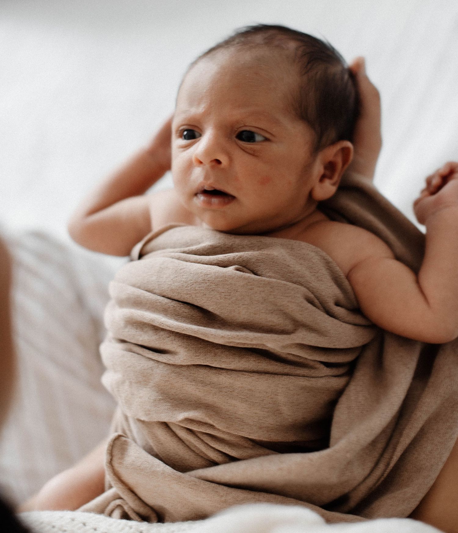 Oakville in-home photographer of baby looking up at mom