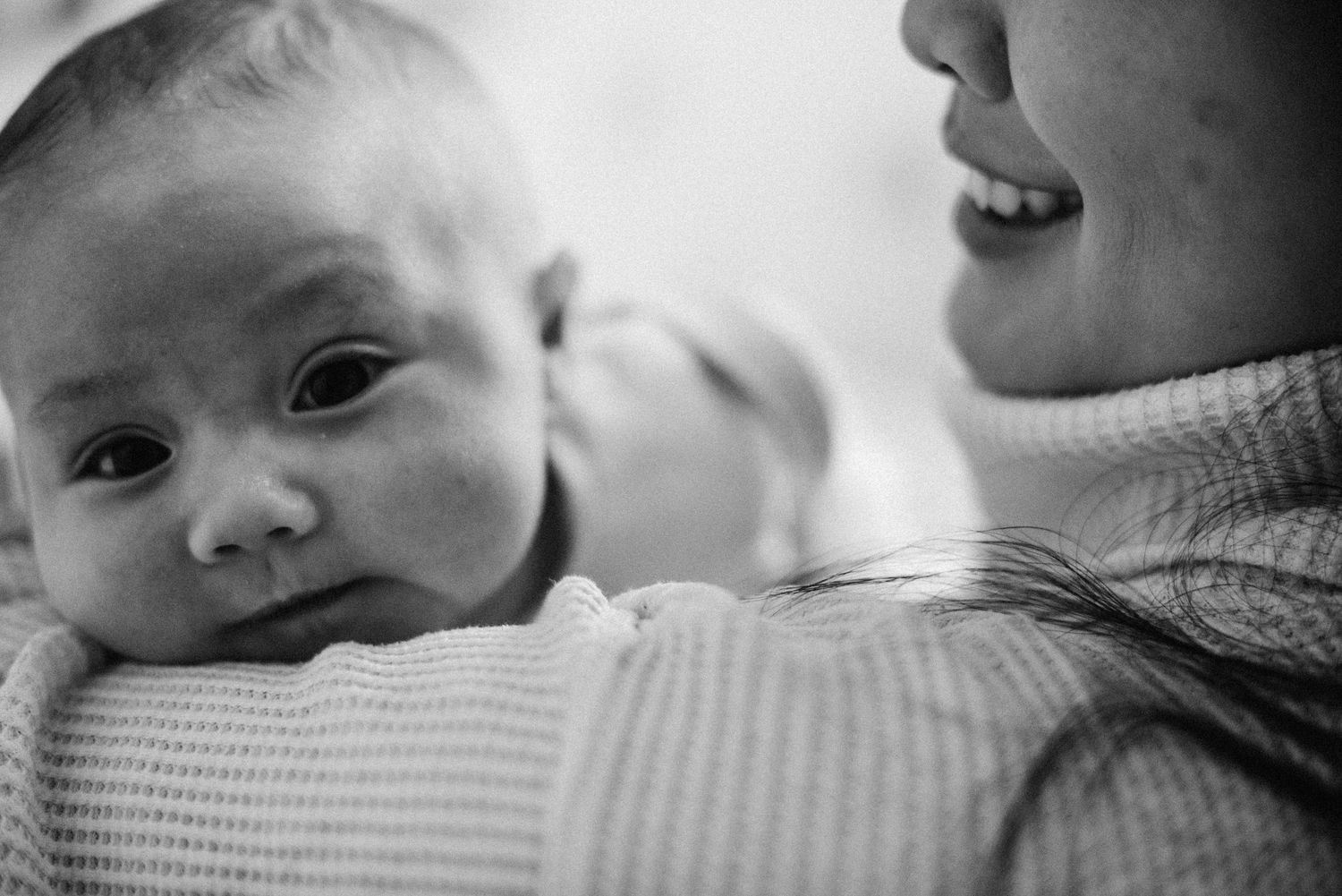 Baby resting on mother’s chest during an in-home lifestyle photography session