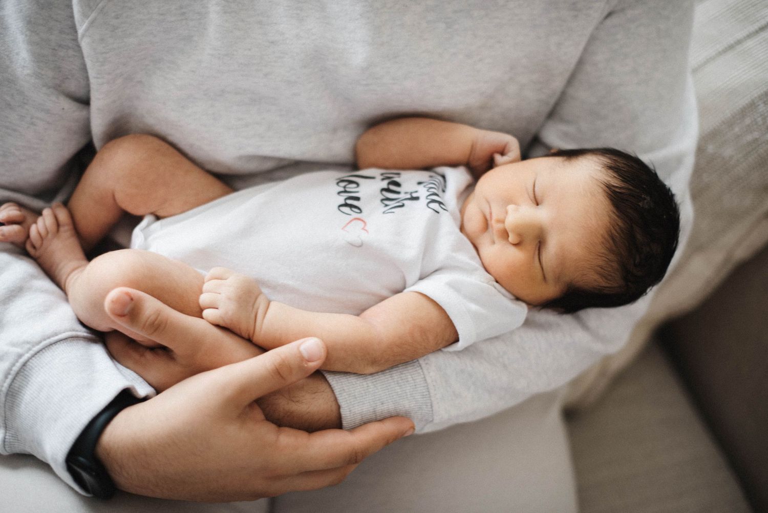 Emotional family portrait of big brother holding newborn