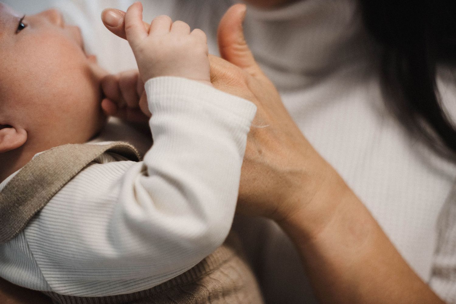 Oakville photographer capturing baby putting mom's fingers in mouth