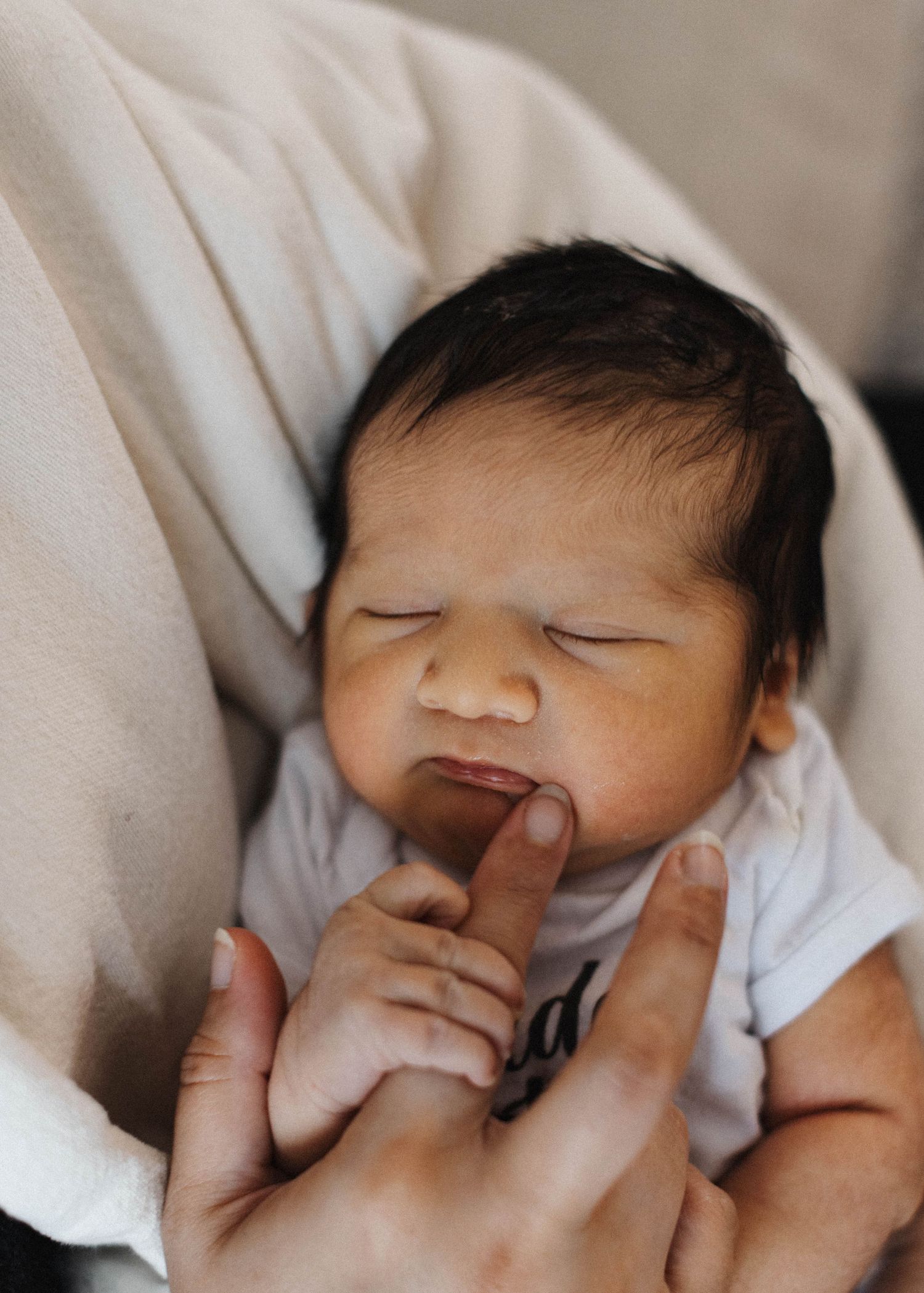 Natural light newborn photography showing mom and children sharing a quiet moment