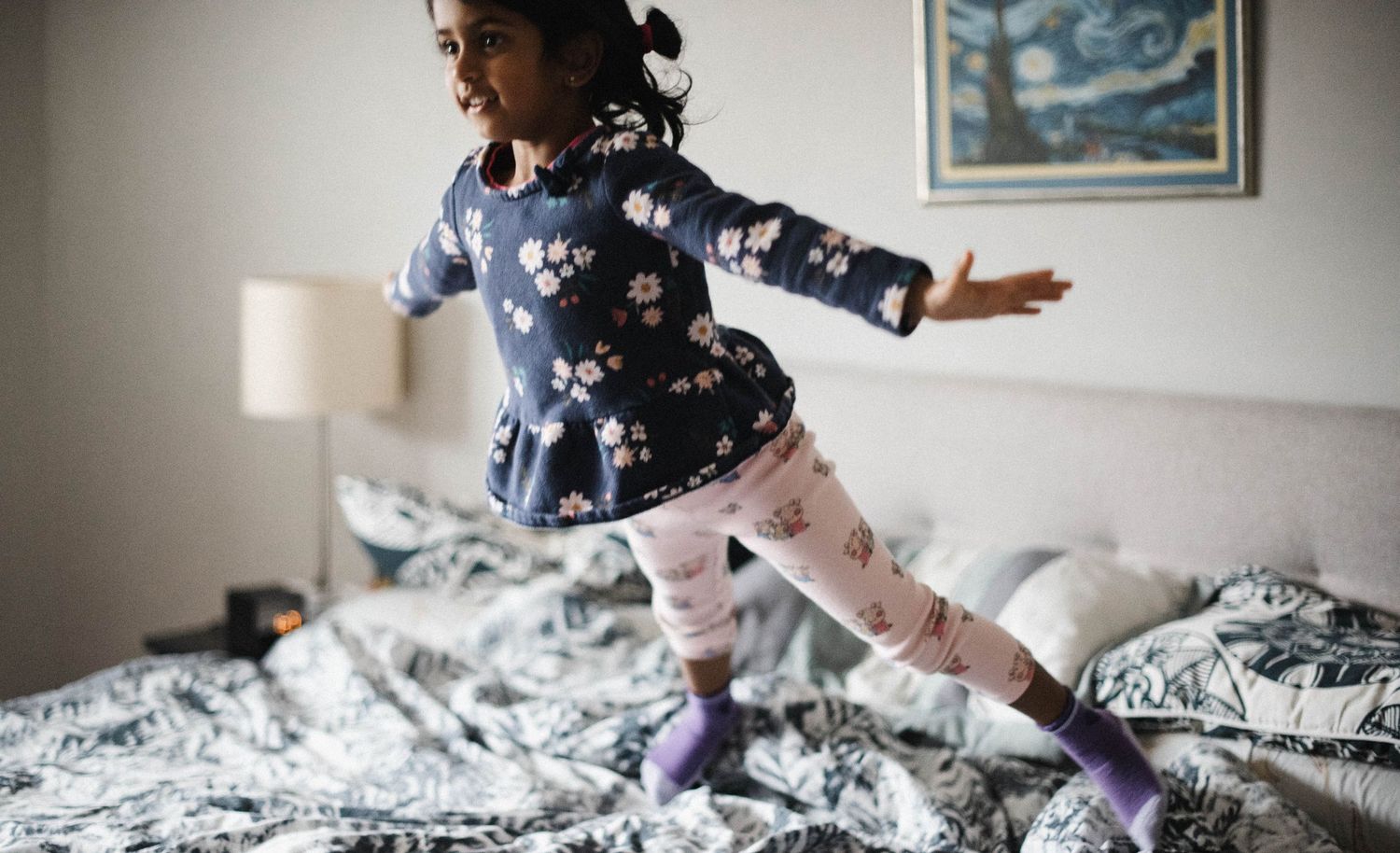 Mississauga in-home photographer documenting children having fun jumping in bed