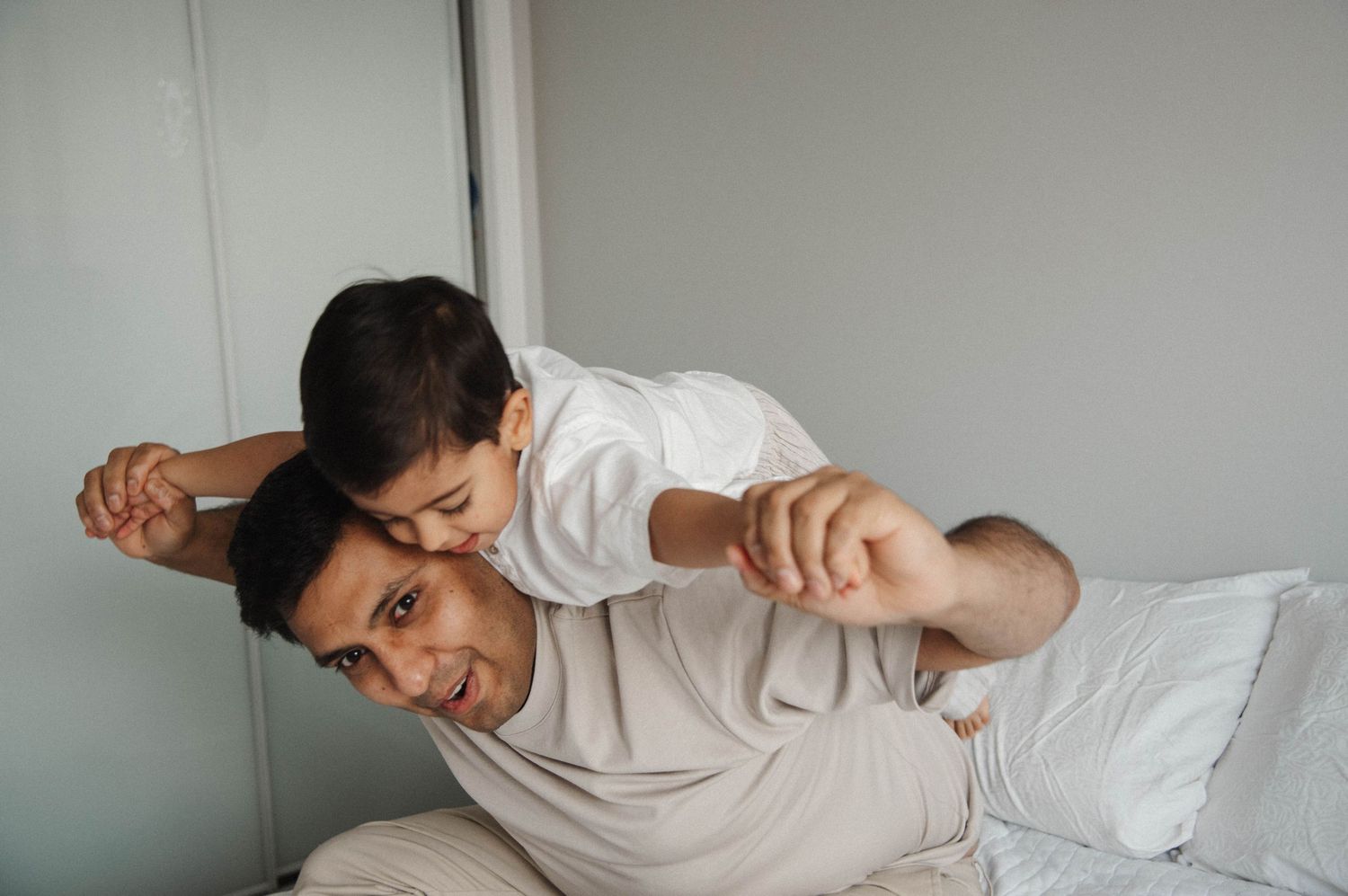 Mississauga family lifestyle photographer capturing father playing airplane with son