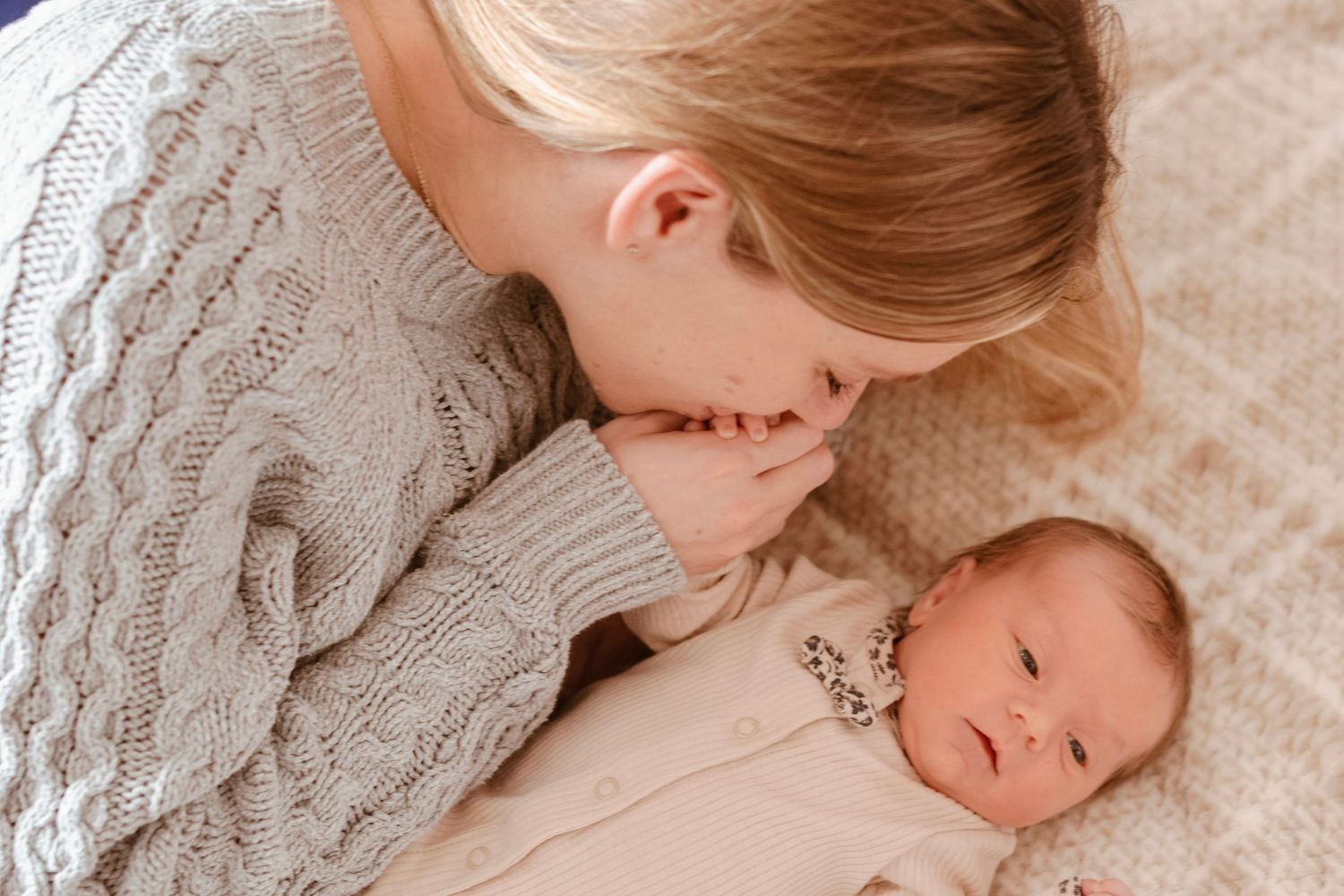 Oakville family photographer capturing real life moment between mom and newborn