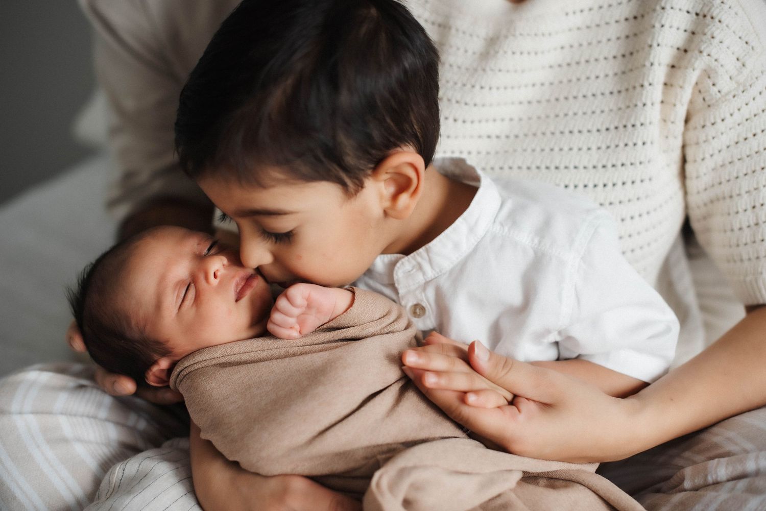 Candid newborn photography session focused on gentle family connection