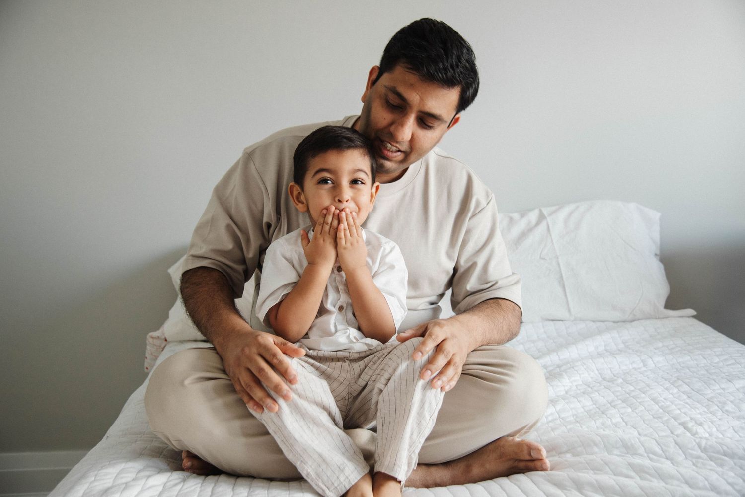 Oakville lifestyle photographer capturing father and child playing in bed