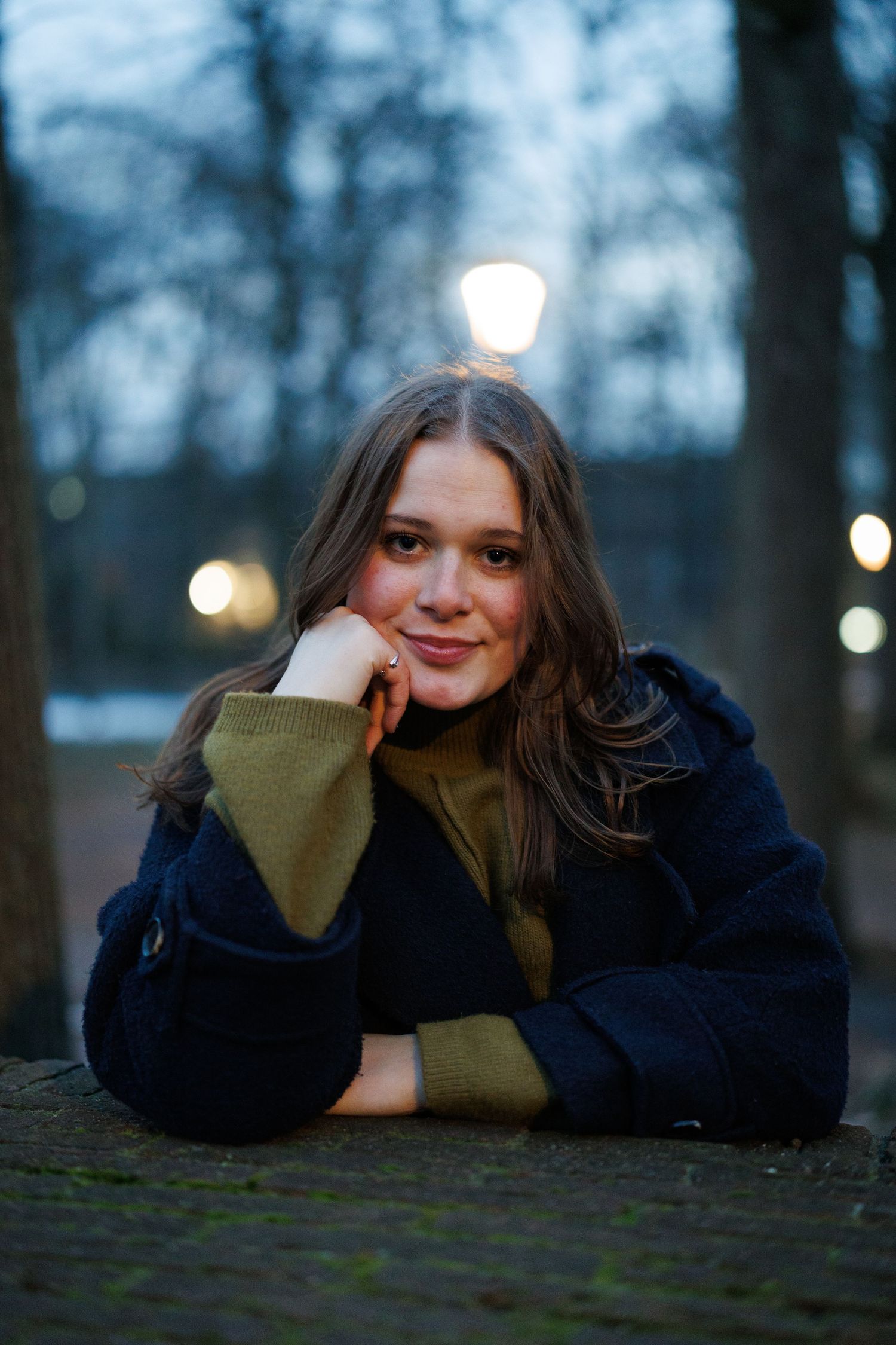 Portretfoto van een vrouw in een winterpark in alphen aan den rijn met sneeuw, vastgelegd met natuurlijk licht.